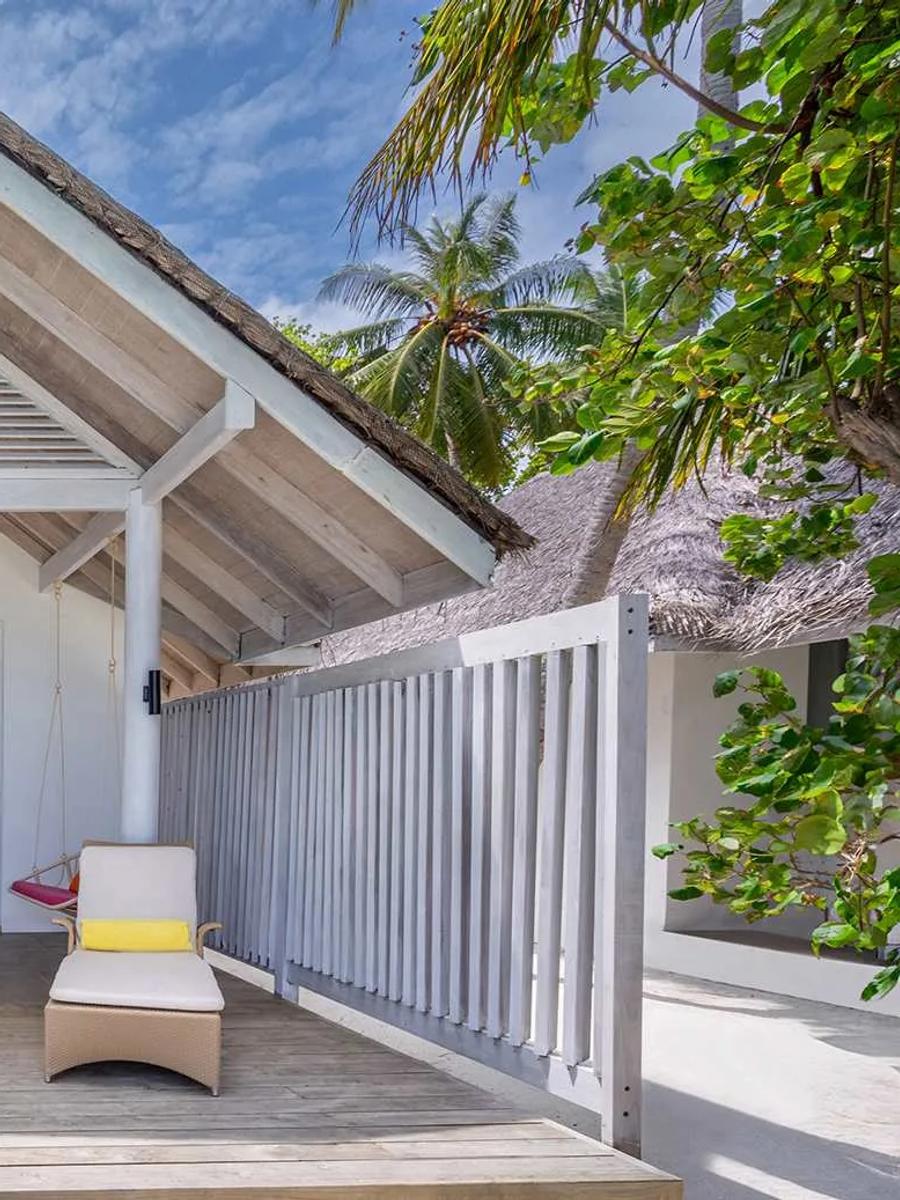 The exterior of a Beach Villa with Private Pool, its gabled thatched roof and deck loungers
