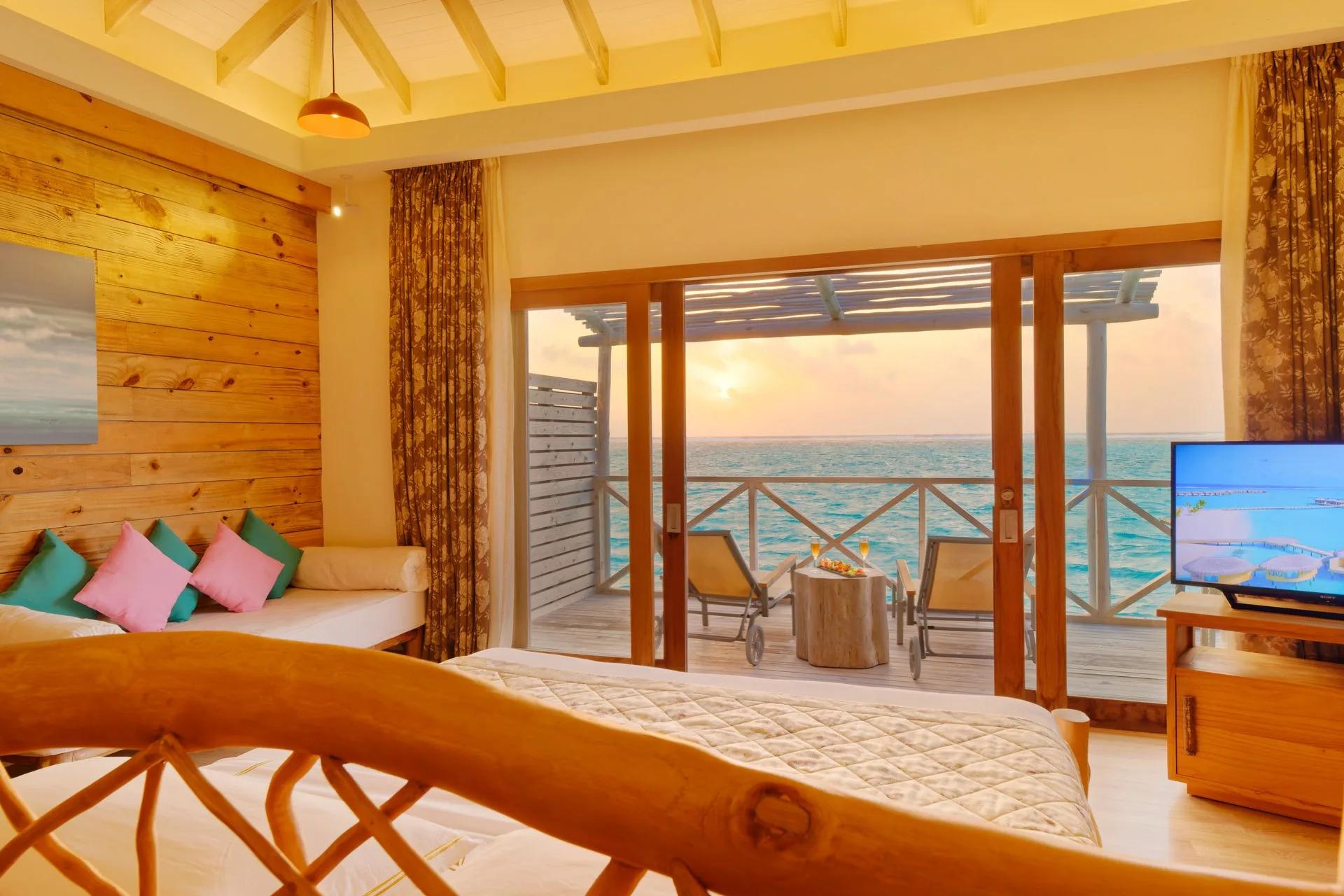 A Lagoon Suite (Dolphin Villa) at You & Me Maldives, an overwater suite facing sunset