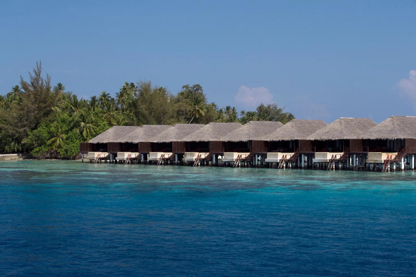 Interior of a Water Villa with Pool, daybed on the deck and bedroom opening onto the lagoon
