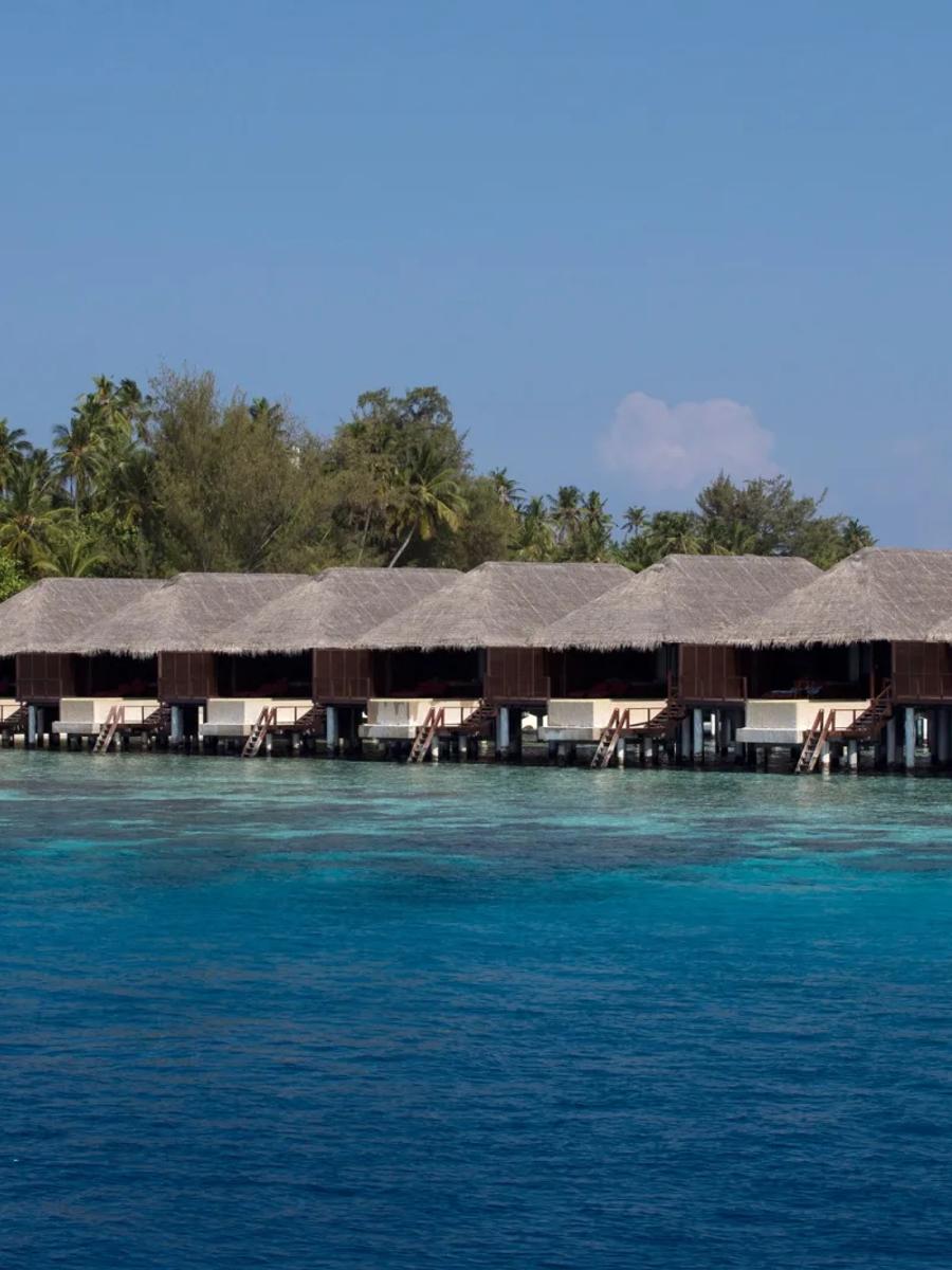 Interior of a Water Villa with Pool, daybed on the deck and bedroom opening onto the lagoon