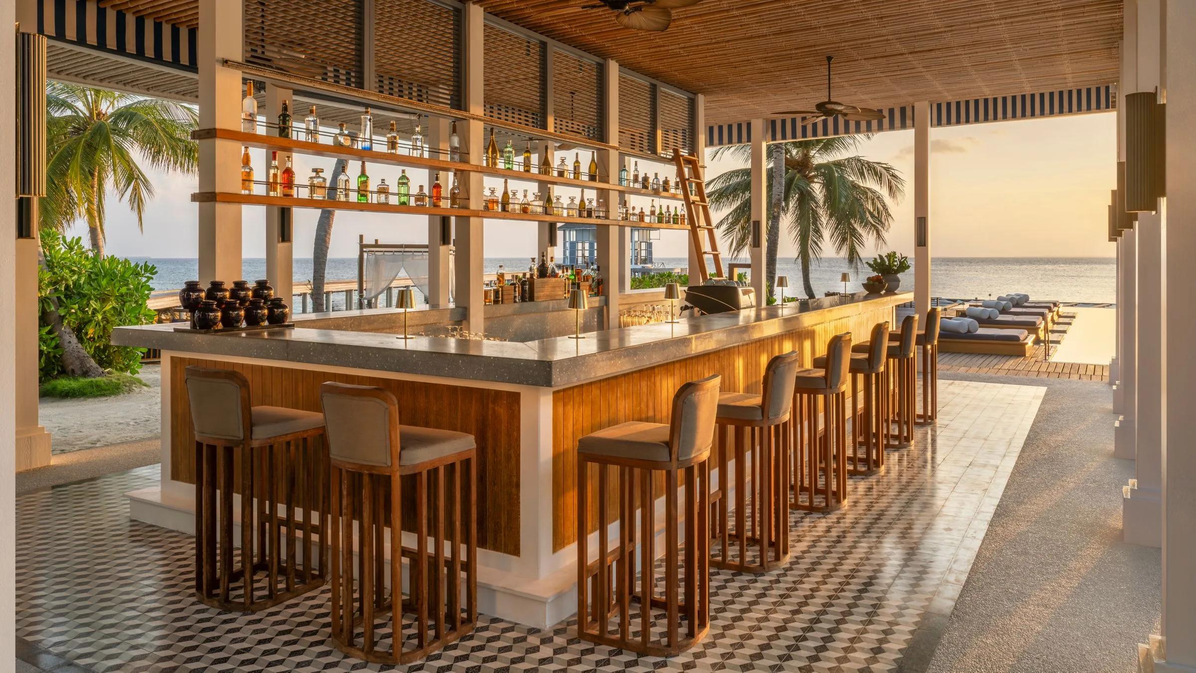 Bell Bar's lounge seating at sunset, angled toward the lagoon