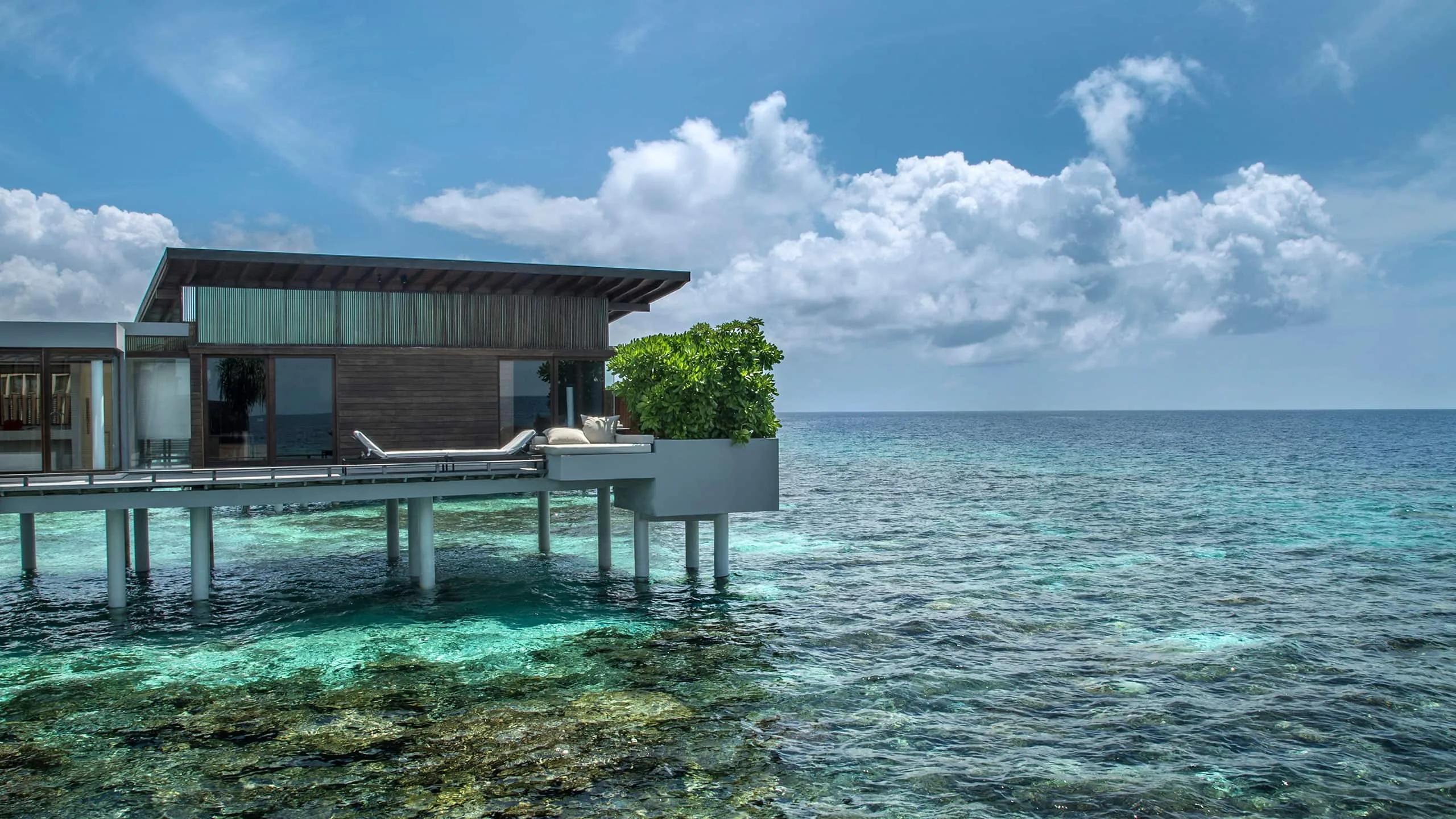 An Overwater Villa's private deck with sun loungers, set directly above the reef