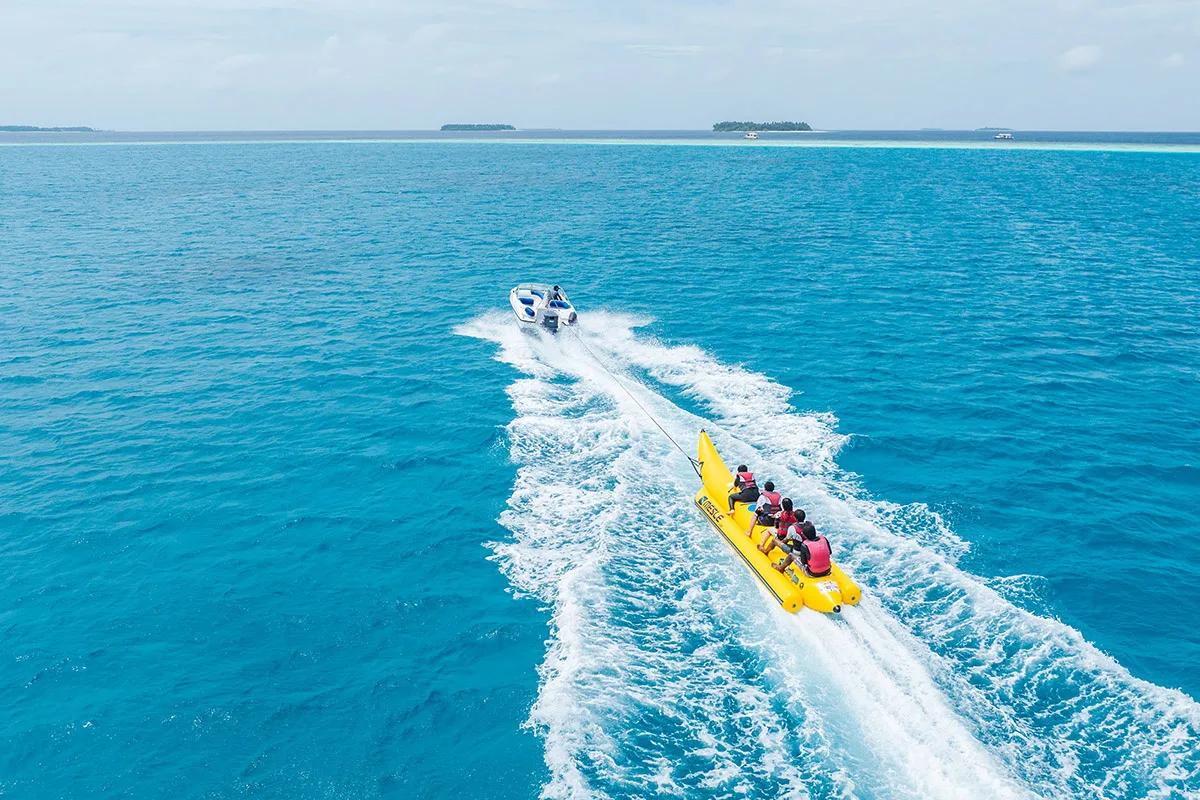 Guests riding a banana boat off Angsana Velavaru
