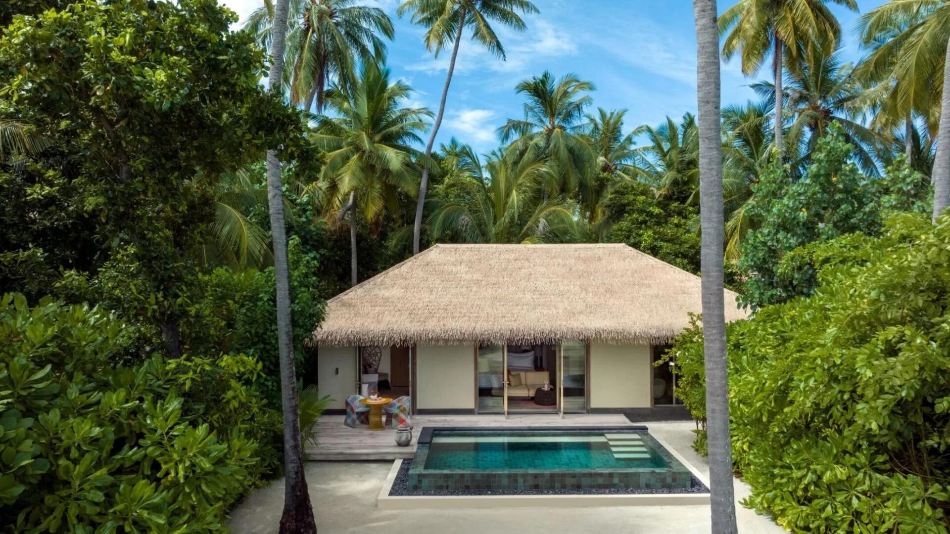The living and bedroom area of a Family Beach Pool Villa, opening onto a private pool deck