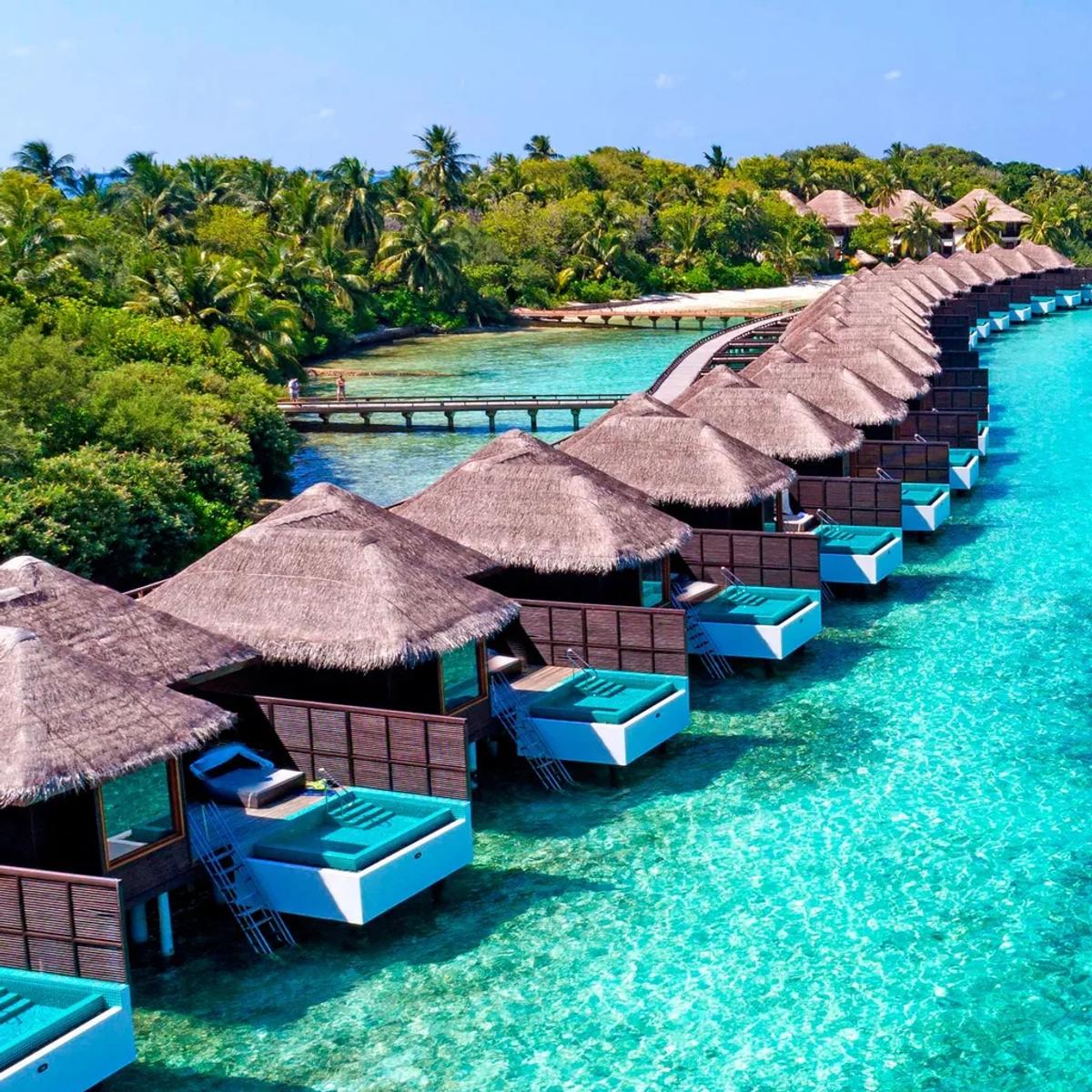 Aerial view of the overwater villa row at Sheraton Maldives Full Moon Resort & Spa, private plunge pools lining the lagoon-facing deck of each villa