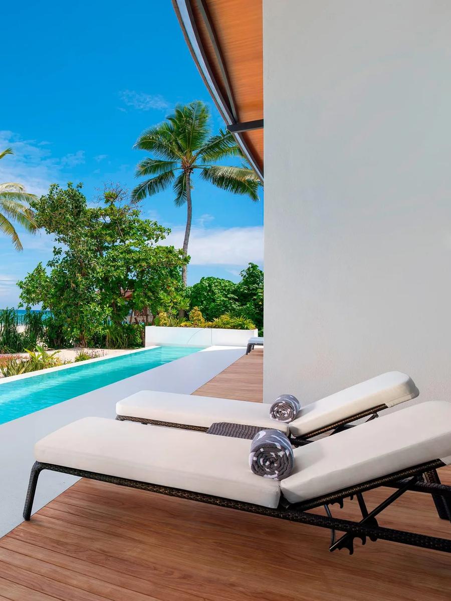 The long lap pool of a Heavenly Beach Residence, running beside the beach toward the lagoon