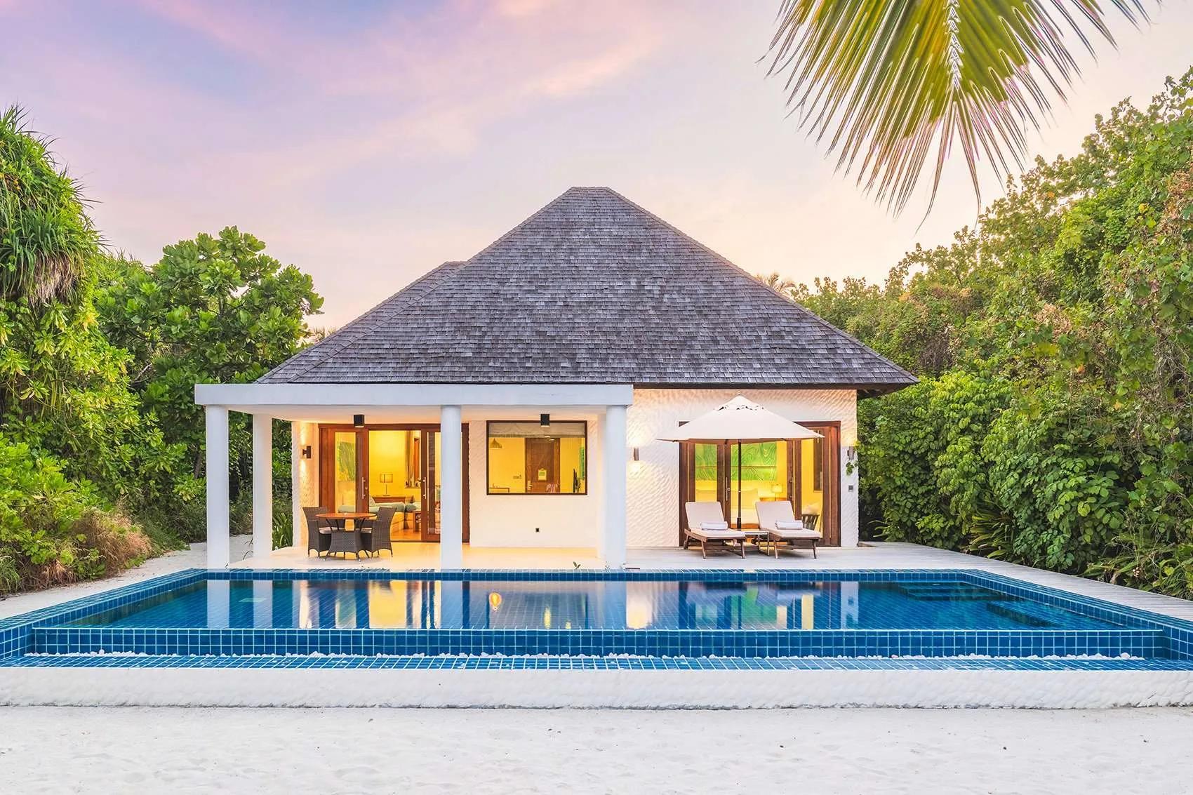 A Deluxe Beach Residence with Lap Pool at twilight, its rectangular lap pool lit blue, Hideaway Beach Resort & Spa