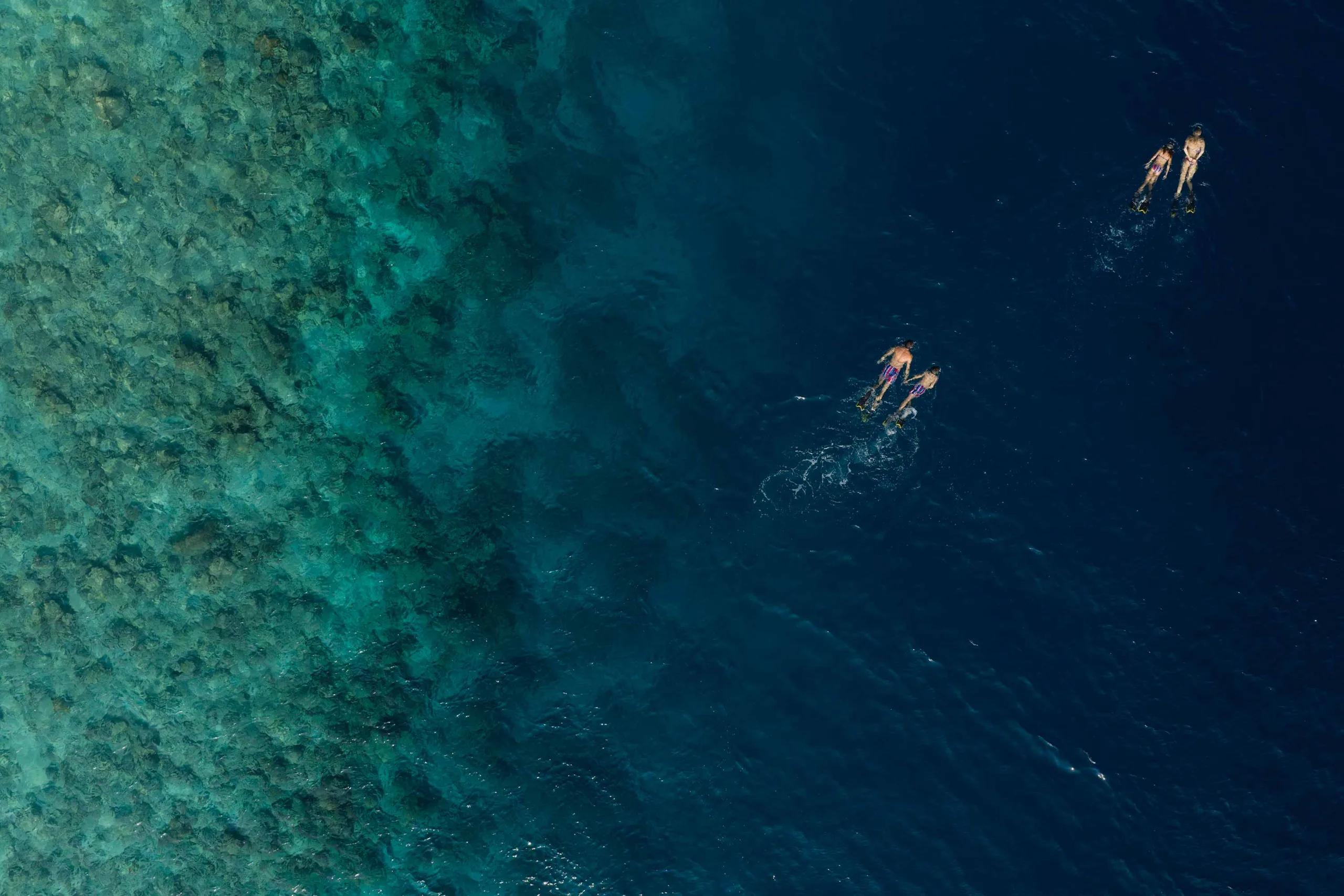 An aerial view of Emerald Maldives Resort & Spa's private island in Raa Atoll, beach and overwater villas ringing the lagoon