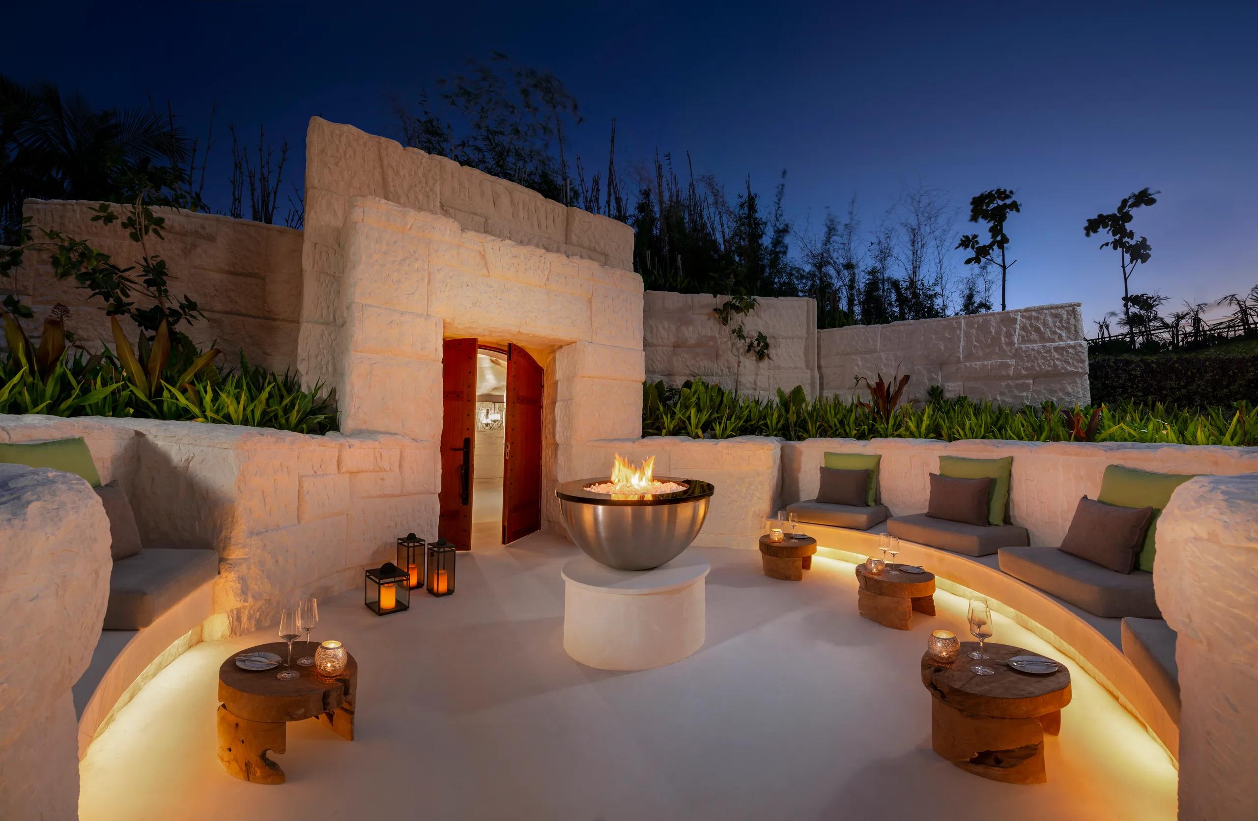 The cave-inspired dining room at The Rock, Waldorf Astoria Maldives Ithaafushi, built from Jordanian limestone around a 200-year-old jarrah wood table