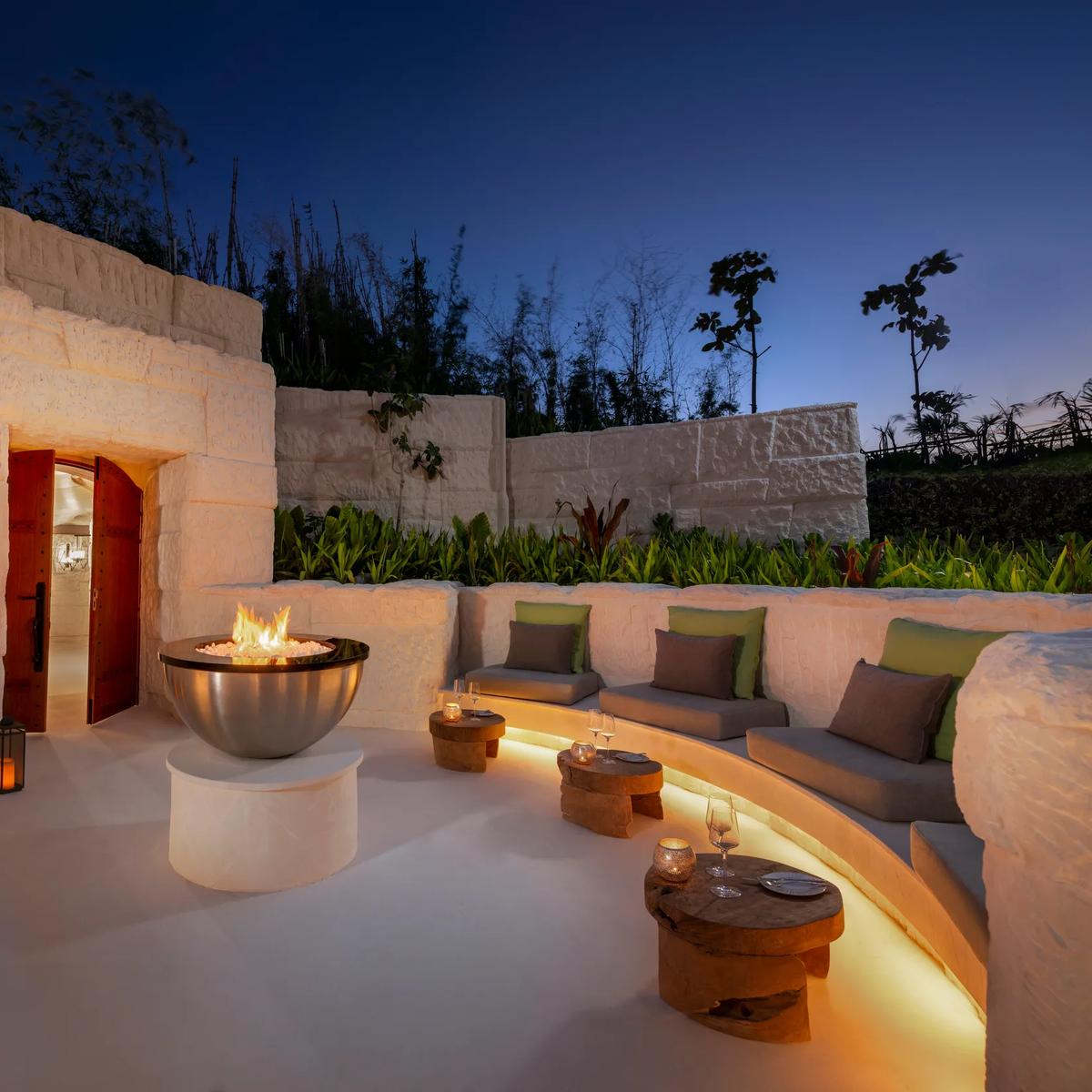 The cave-inspired dining room at The Rock, Waldorf Astoria Maldives Ithaafushi, built from Jordanian limestone around a 200-year-old jarrah wood table