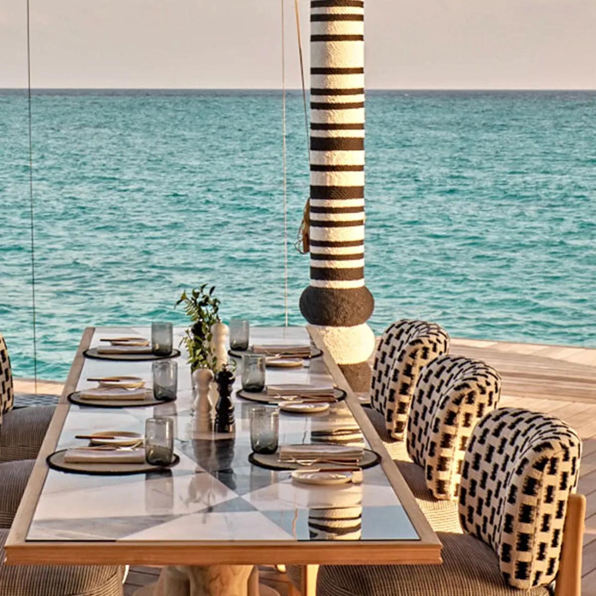 A private dining table set at the water's edge at .Here, laid for an evening meal