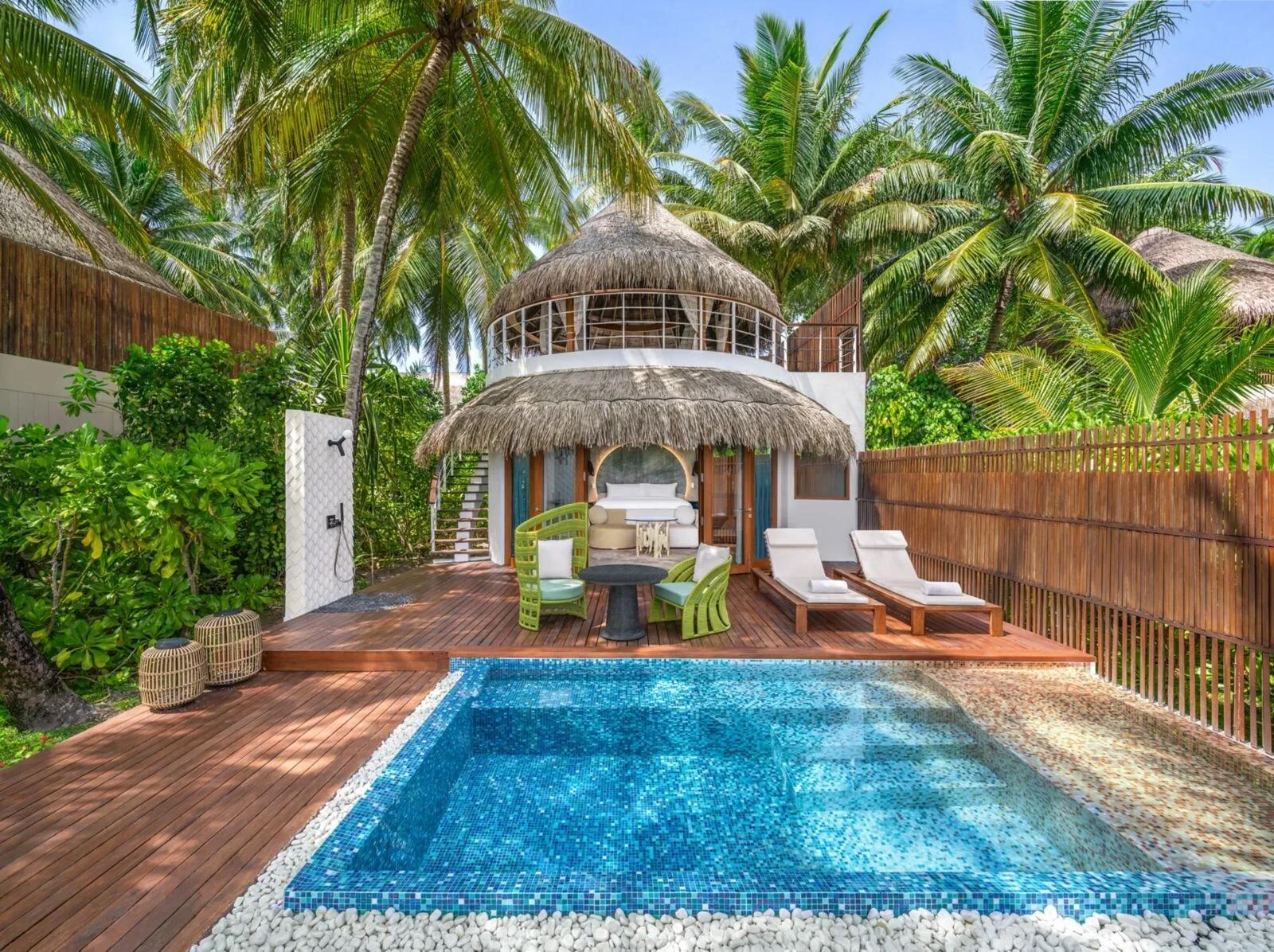 An Escape Beach villa at W Maldives — a two-storey thatched-roof villa with a private pool on its own deck, shaded by palms