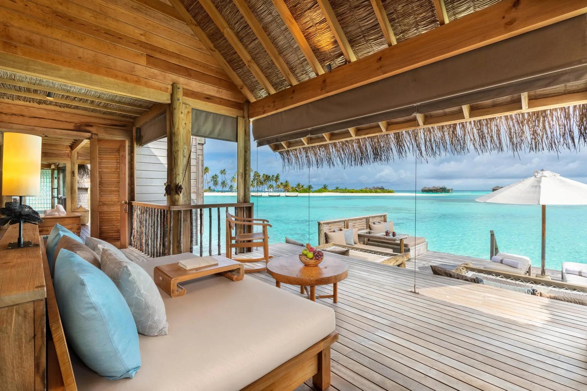 The open-air living room of a Villa Suite at Gili Lankanfushi, with daybed and dining table