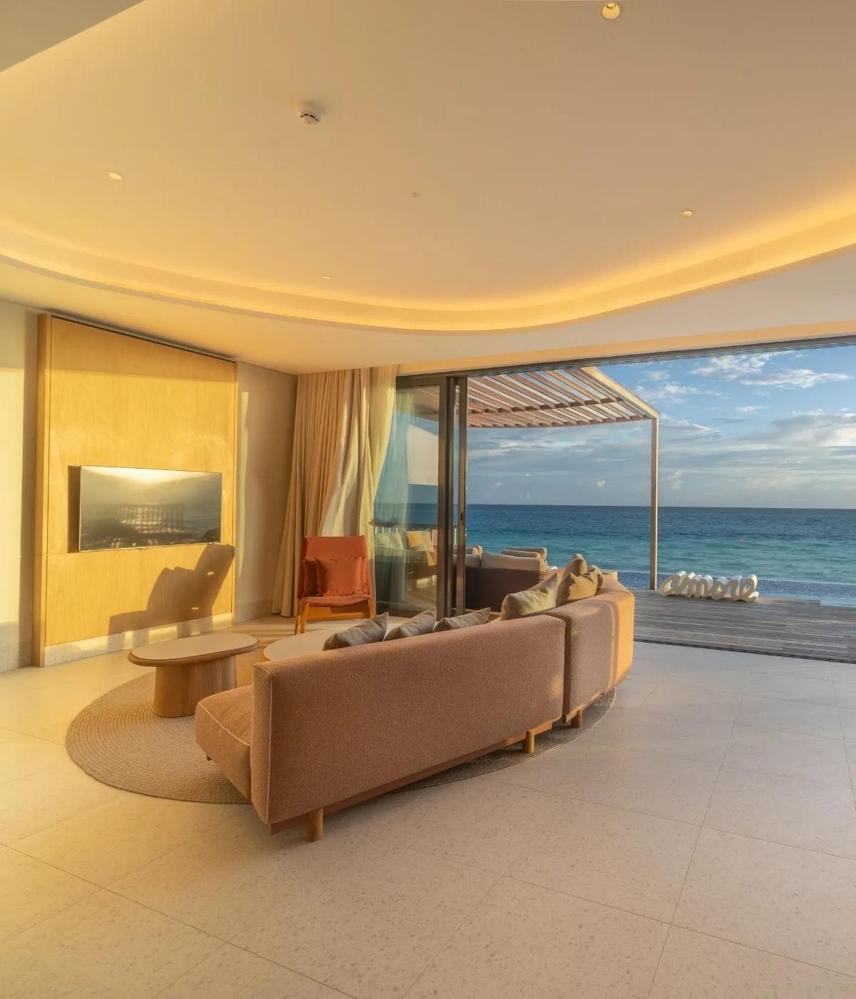 The open living area of a beach villa at SO/ Maldives, sliding doors leading onto a private pool deck facing the ocean — representative of the Family Beach Pool Villa with Capsule; a dedicated photograph was not available