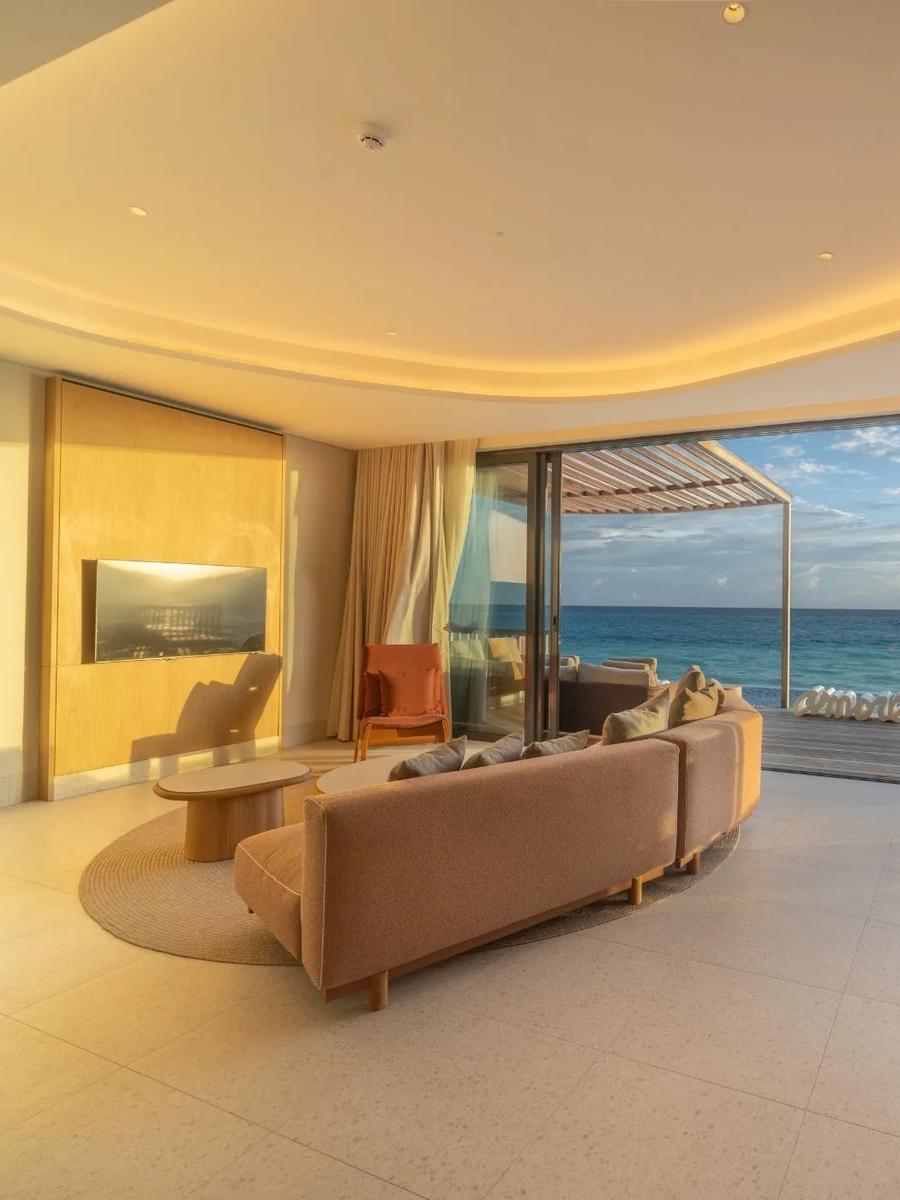 The open living area of a beach villa at SO/ Maldives, sliding doors leading onto a private pool deck facing the ocean — representative of the Family Beach Pool Villa with Capsule; a dedicated photograph was not available