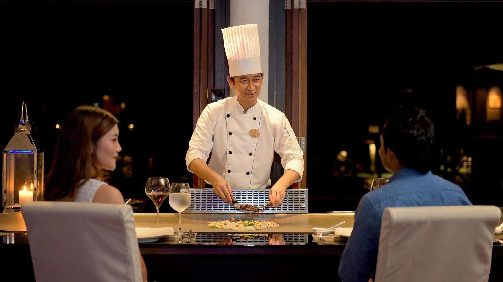 A chef cooking tableside at Teppanyaki, Lily Beach Resort & Spa