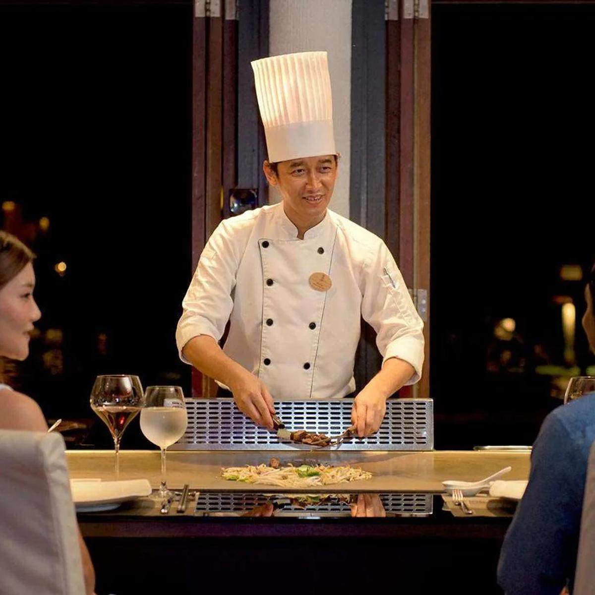 A chef cooking tableside at Teppanyaki, Lily Beach Resort & Spa