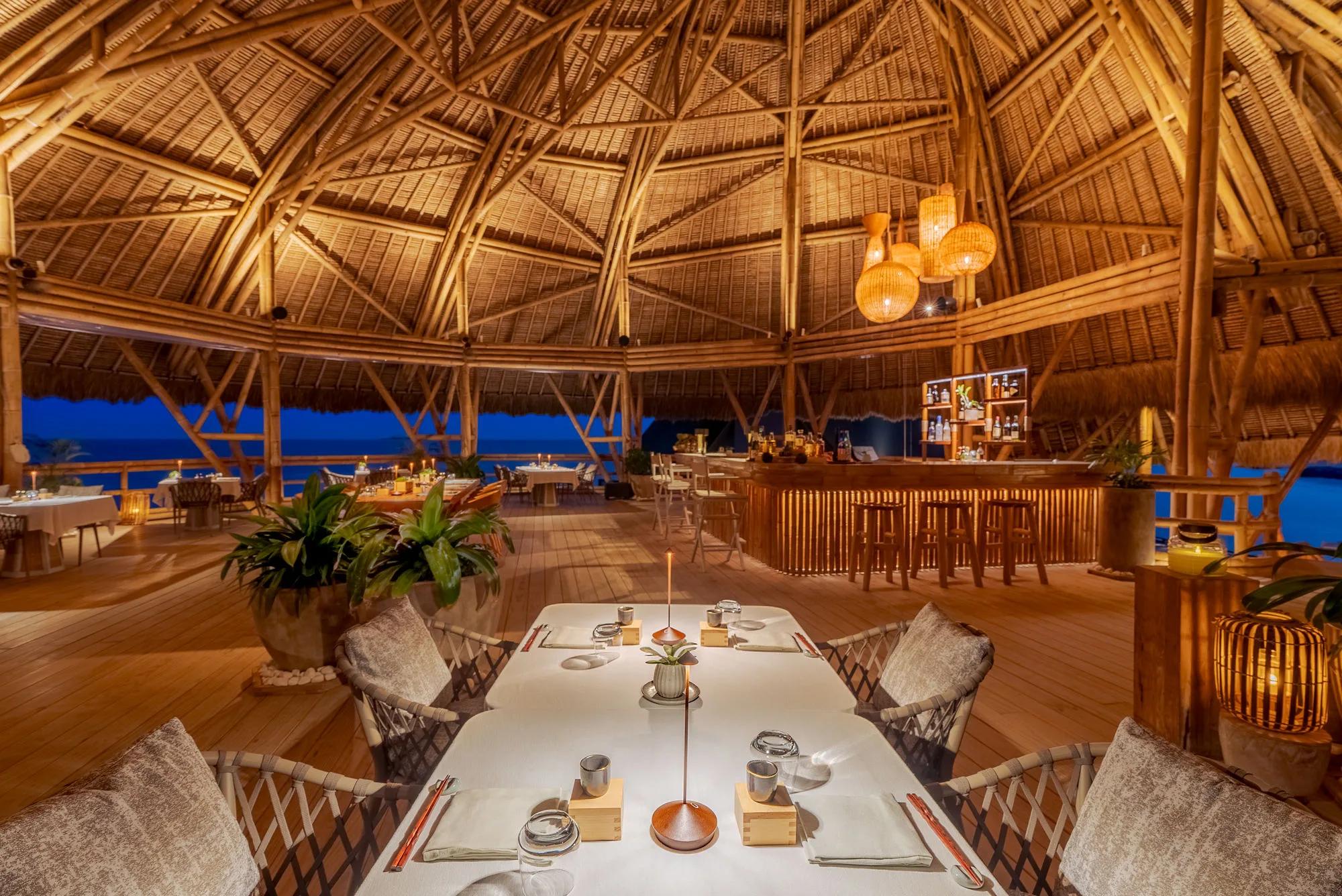 The dining room at Yutori, Joali Being's Japanese restaurant, surrounded by ocean