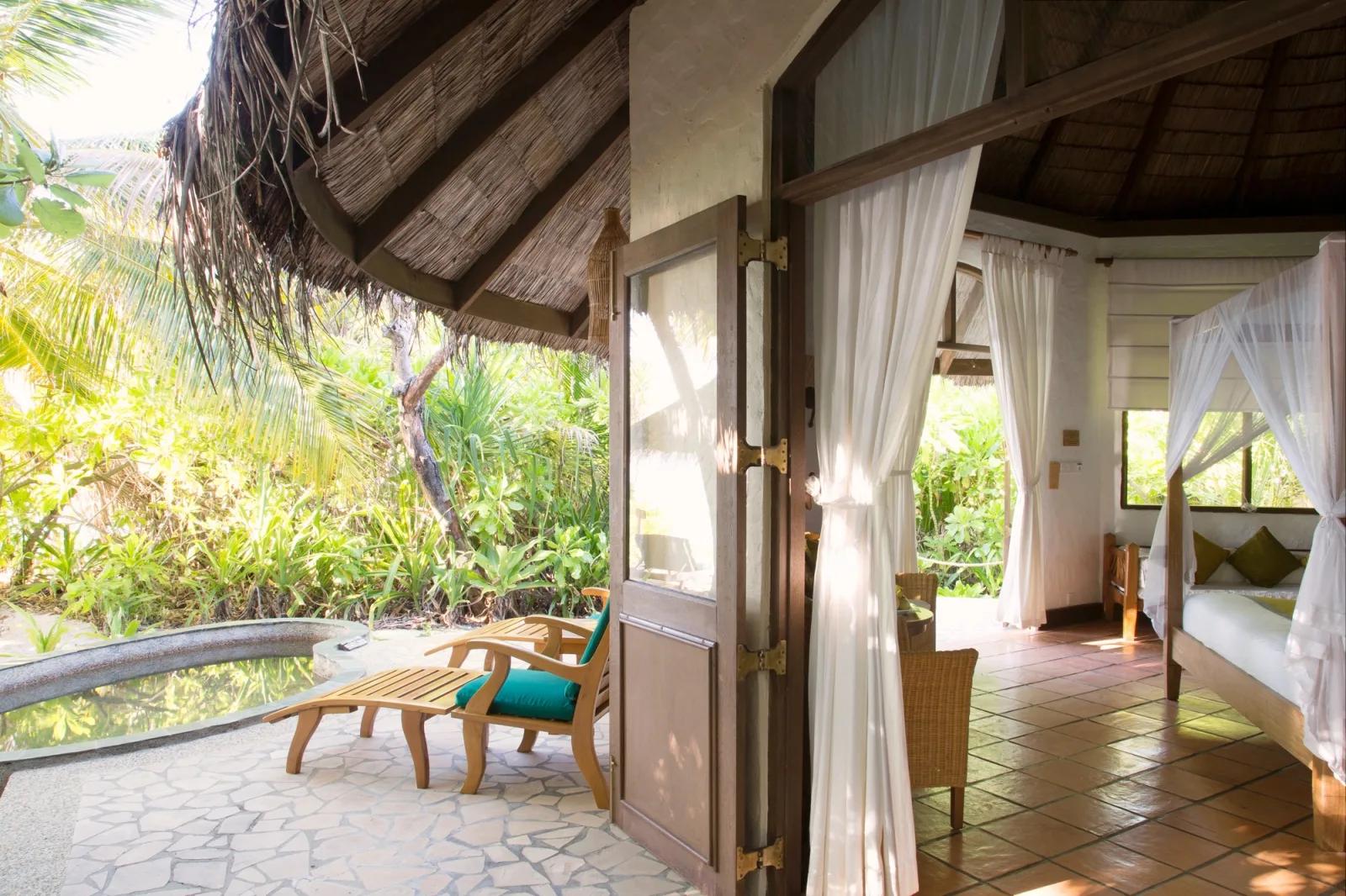 A private plunge pool on a villa deck, framed by dense tropical foliage