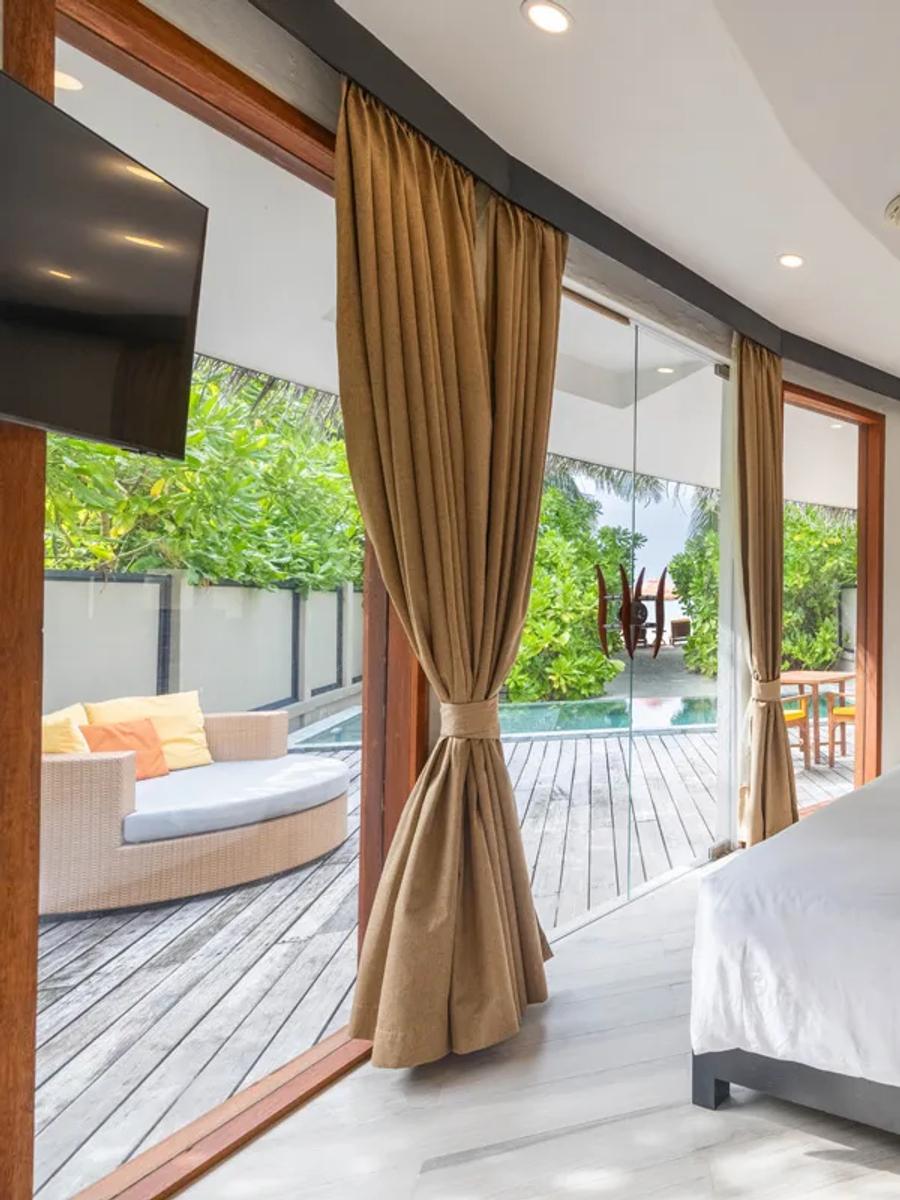 Exterior of a Beachfront Family Pool Villa at Angsana Velavaru, its two huts and shared garden