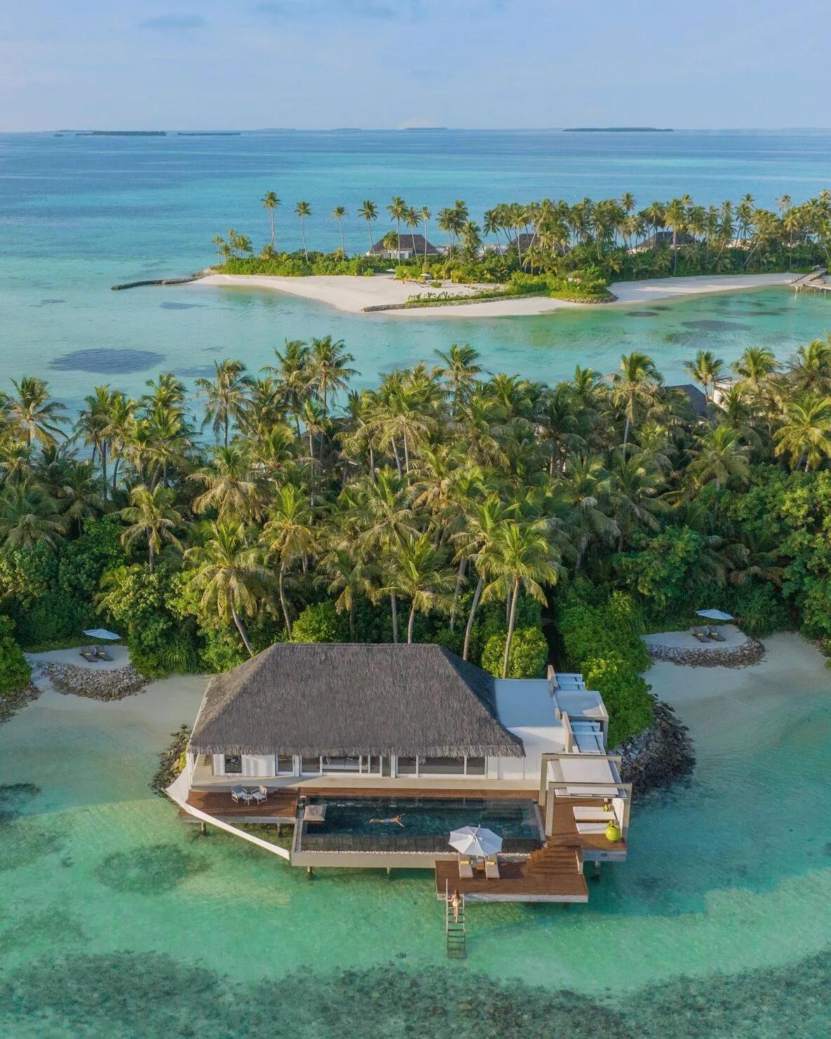 A Garden Water Villa's overwater pool deck backed by garden and jungle, with beach visible on either side
