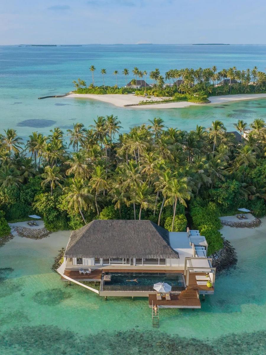 A Garden Water Villa's overwater pool deck backed by garden and jungle, with beach visible on either side