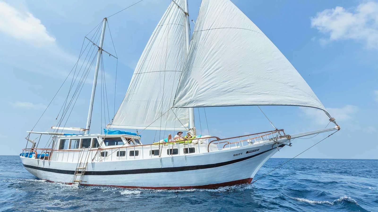 The sailing yacht Britt under full sail with guests relaxing on deck