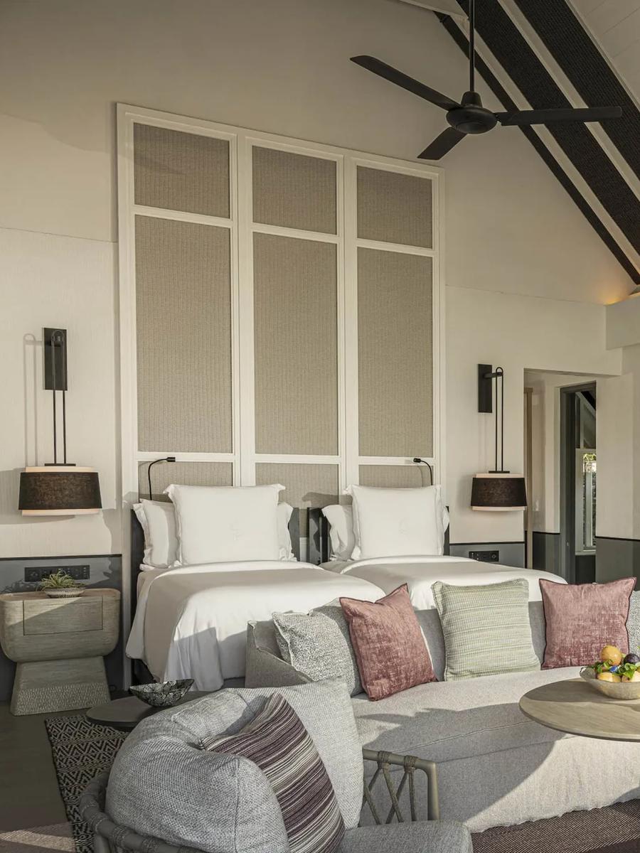 The twin-bed bedroom of a Two-Bedroom Oceanfront Villa, with its own wet bar and ceiling fan