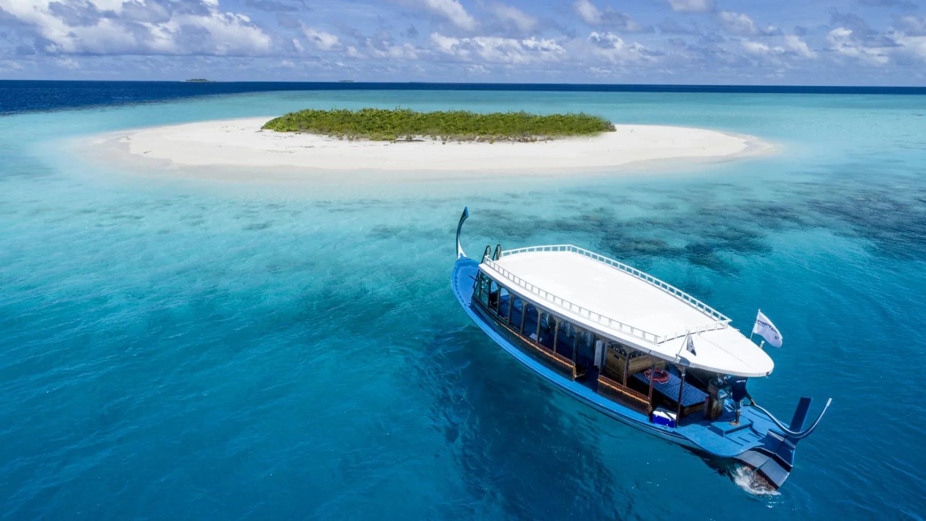 An aerial view of a sandbank islet and traditional dhoni boat near Mercure Maldives Kooddoo Resort, Gaafu Alifu Atoll
