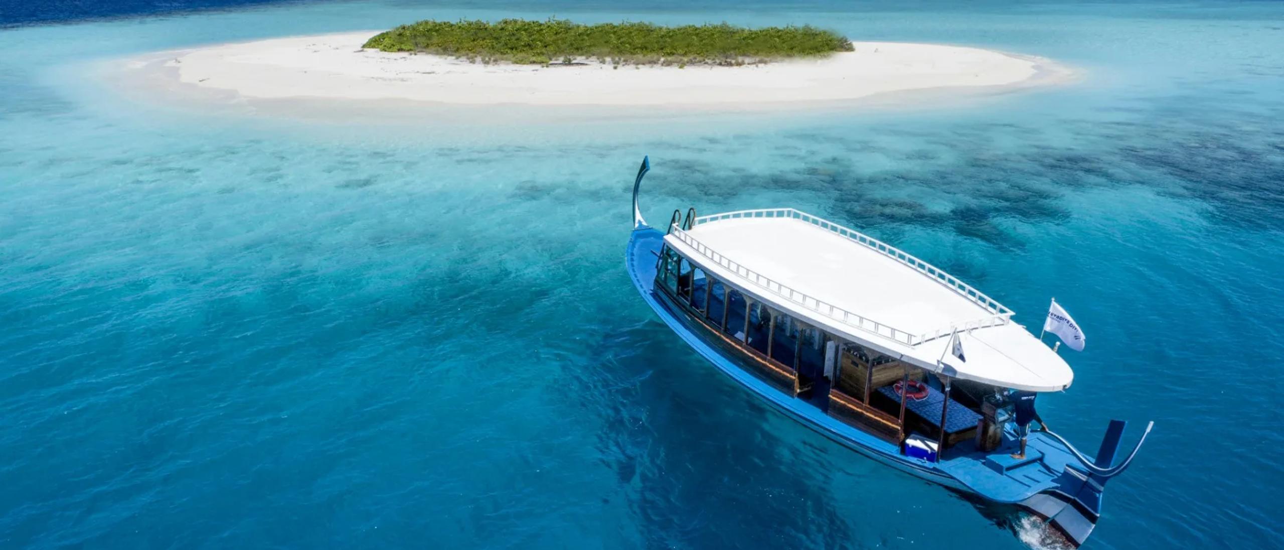 An aerial view of a sandbank islet and traditional dhoni boat near Mercure Maldives Kooddoo Resort, Gaafu Alifu Atoll