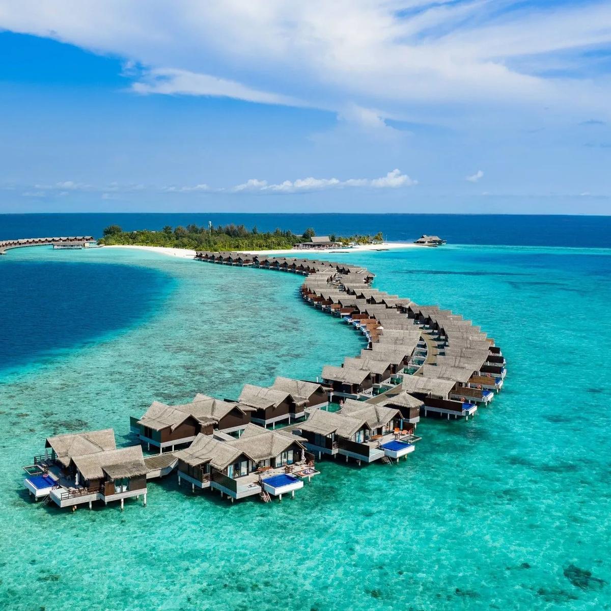 A top-down aerial view of Grand Park Kodhipparu's overwater villas and lagoon in North Malé Atoll