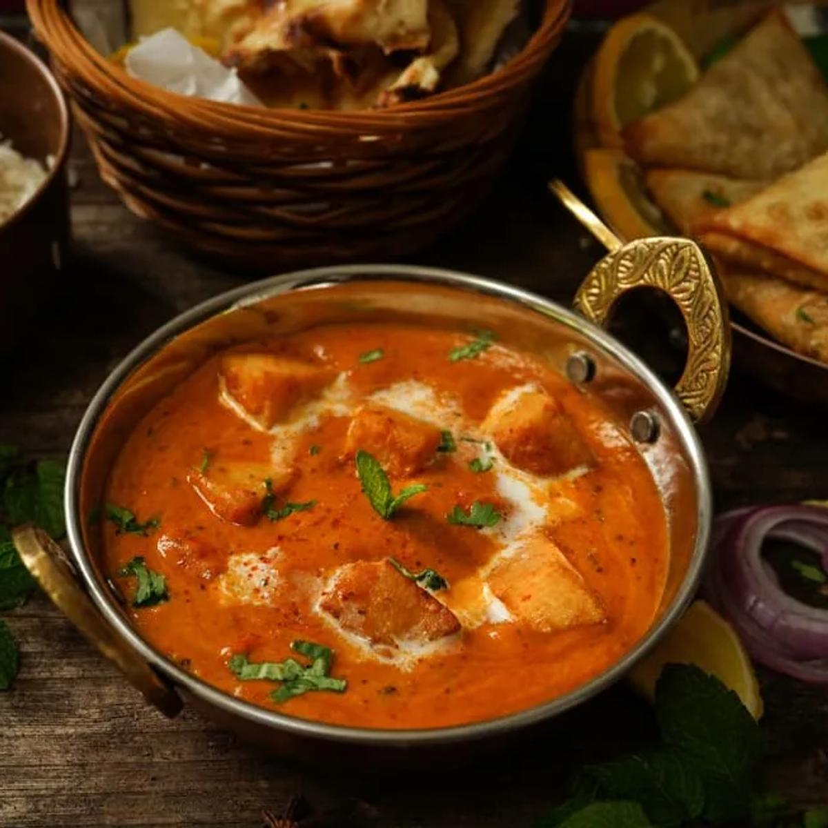 A South Asian thali spread of curry, rice, naan and samosas at Cumin