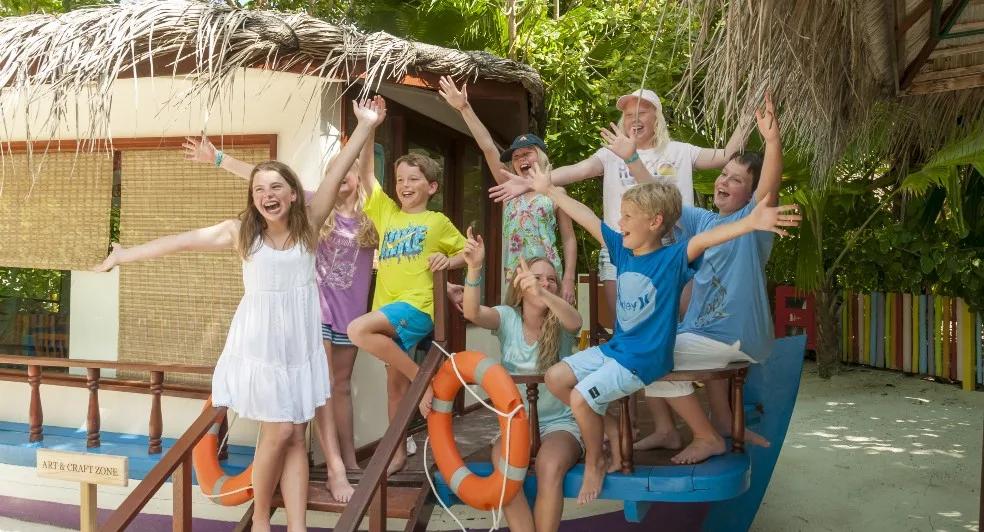 Children gathered on a dhoni-shaped play structure at the resort's children's activity centre