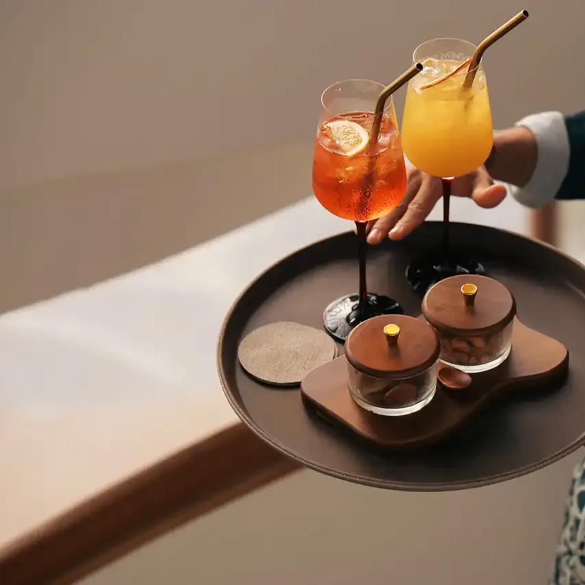 A server presenting a tray of Raagu's cocktails