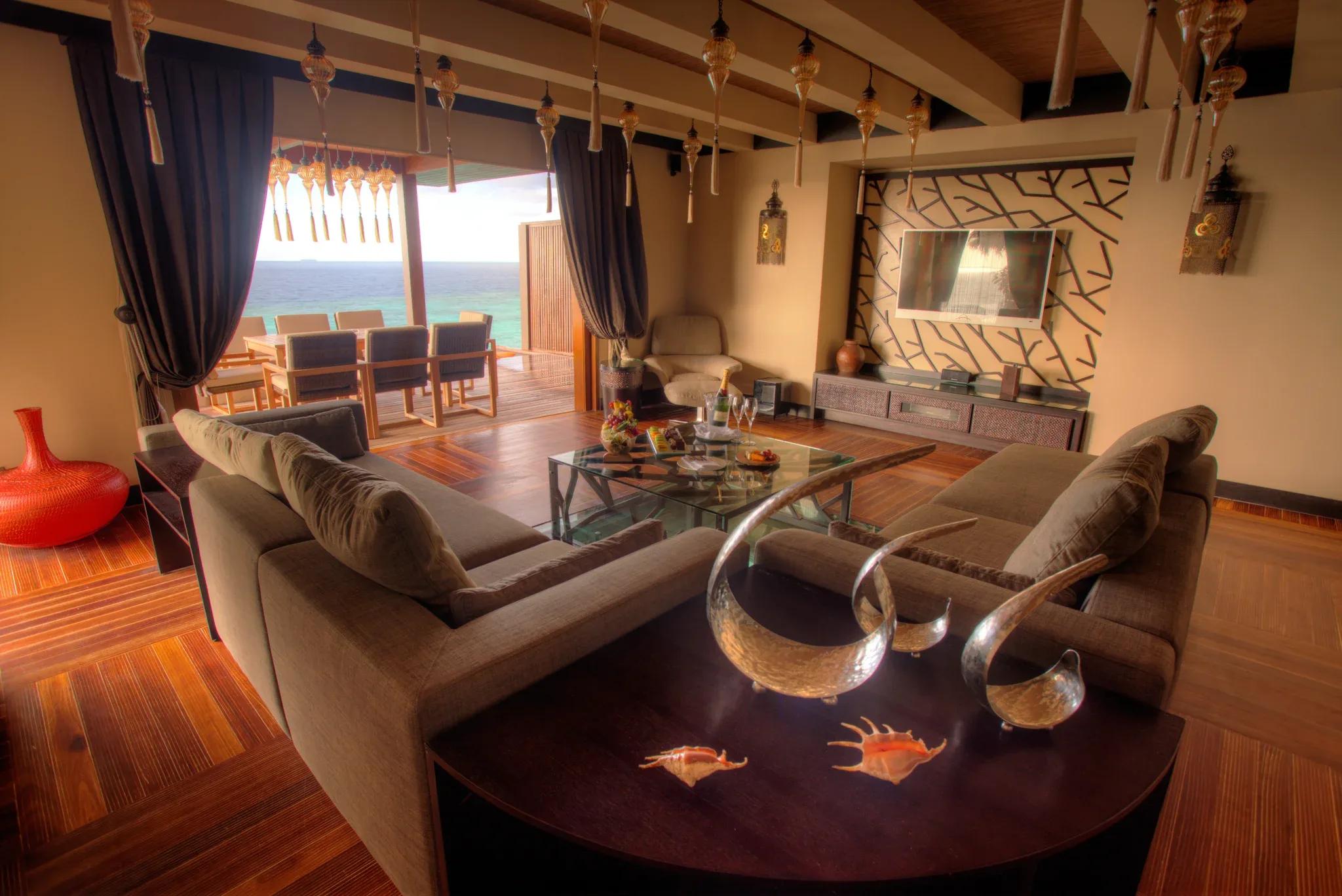 The Royal Ocean Suite's living room, with a view through to the dining deck and open ocean beyond