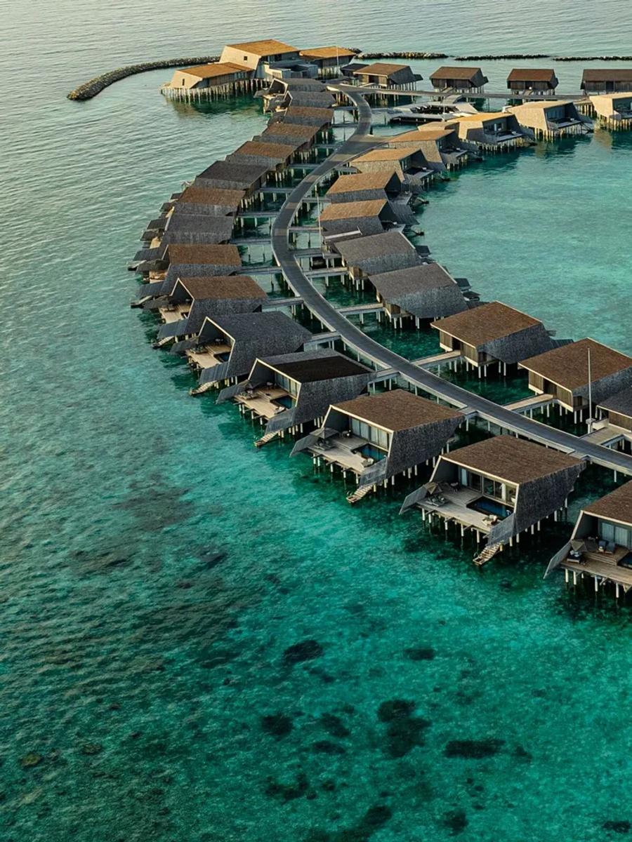 An Overwater Villa's terrace suspended above the turquoise lagoon at The St. Regis Maldives Vommuli Resort