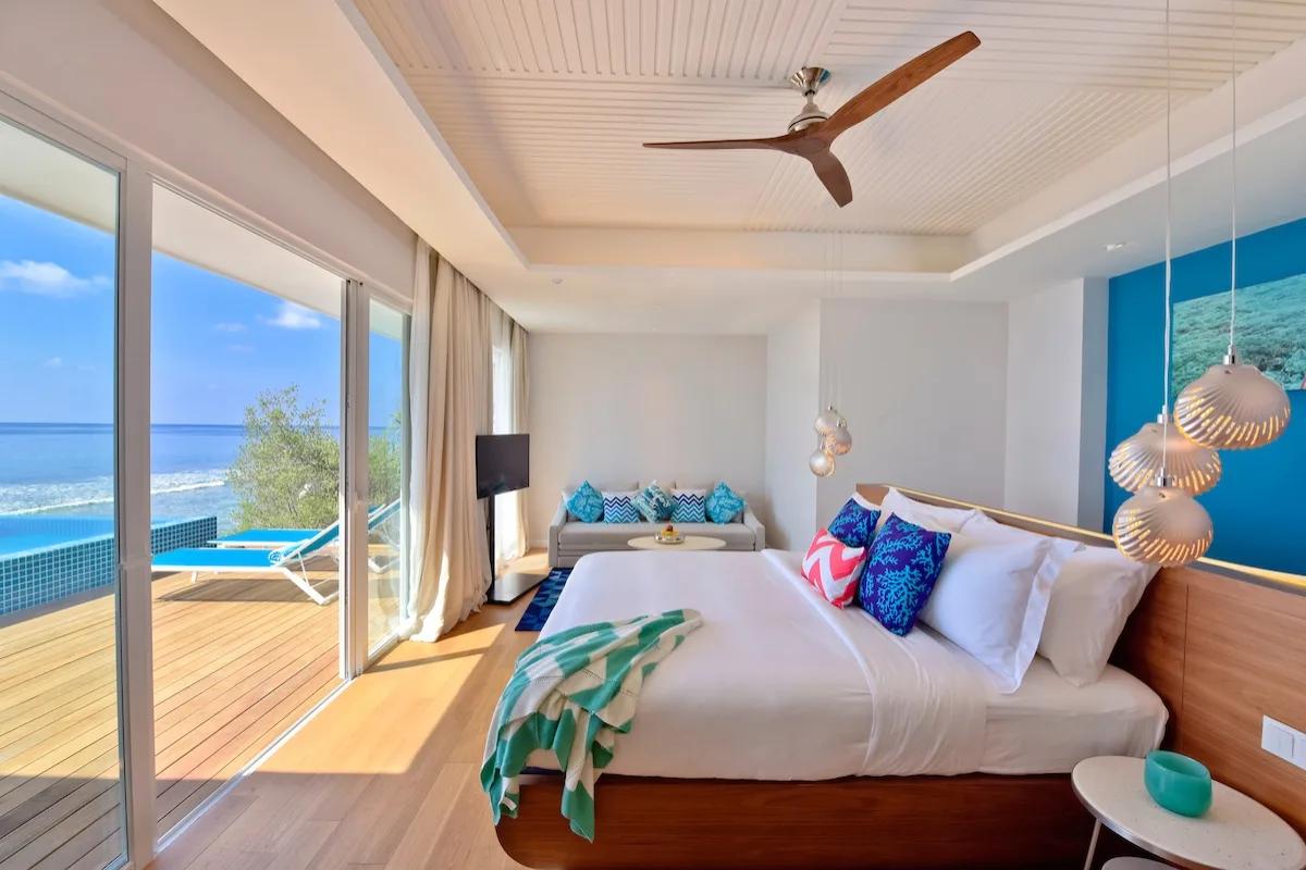 An Ocean Pool Villa's bedroom, with its private pool and deck visible through the sliding doors