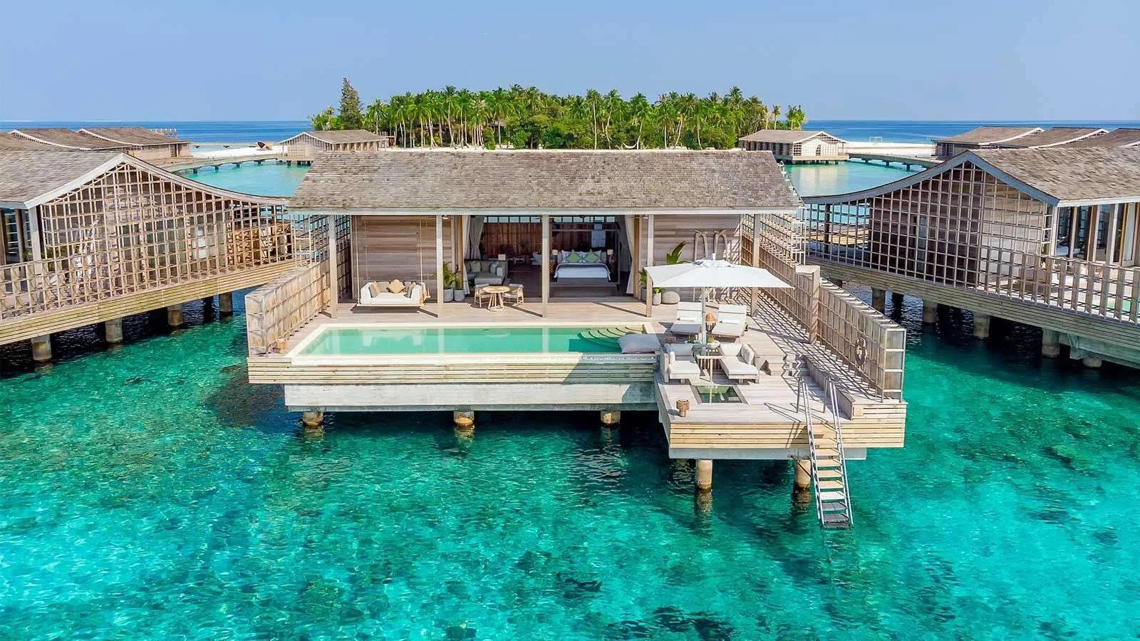 An Ocean Residence's overwater deck and 44-square-metre infinity pool, with Kudadoo's palm canopy behind