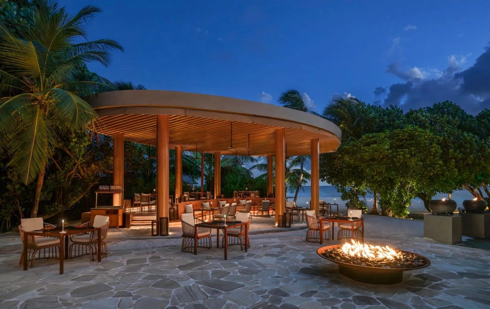 FIRE, W Maldives' beachfront grill, lit for the evening with a fire pit burning on the terrace