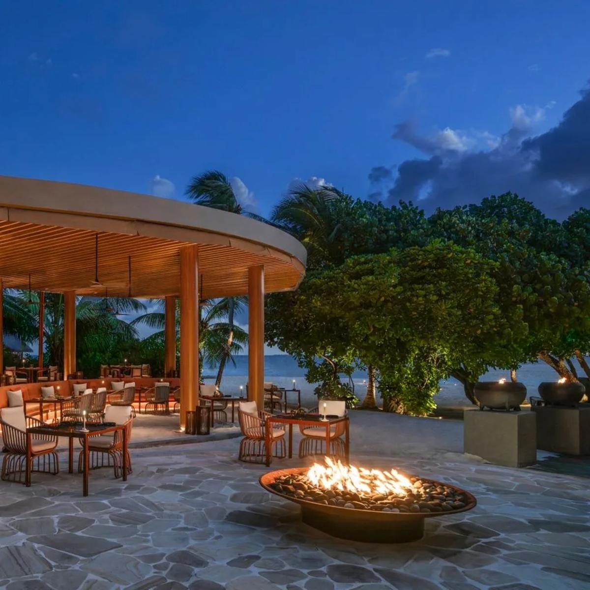 FIRE, W Maldives' beachfront grill, lit for the evening with a fire pit burning on the terrace