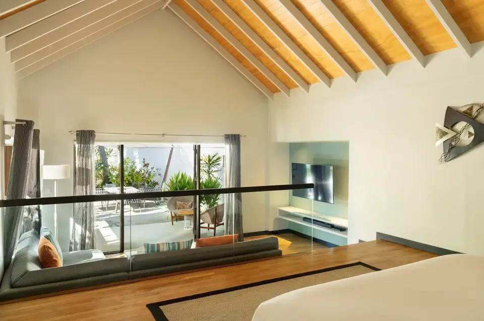 Pool Villa's split-level bedroom loft, looking down over the poolside deck and lounge chairs
