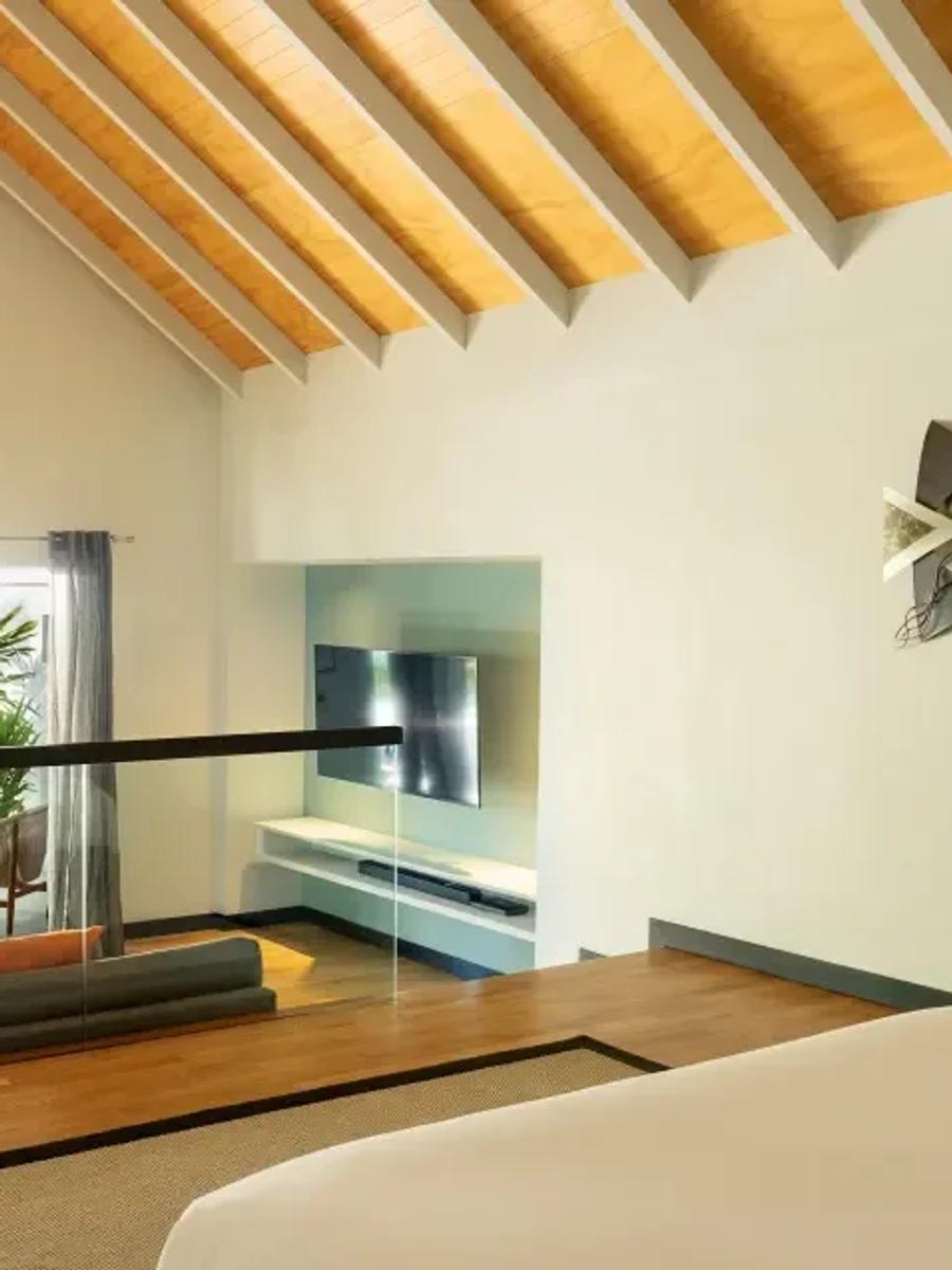 Pool Villa's split-level bedroom loft, looking down over the poolside deck and lounge chairs