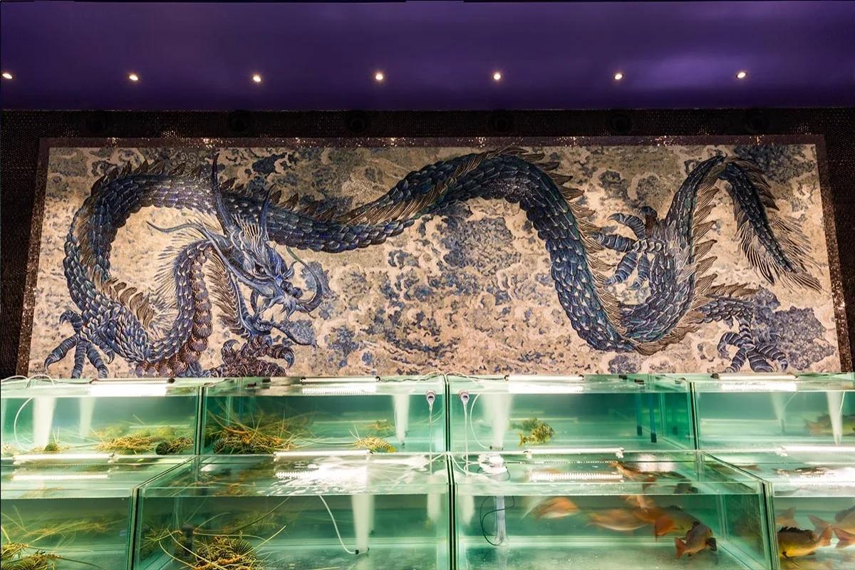 Sea Dragon's mosaic dragon wall above its live seafood display tanks