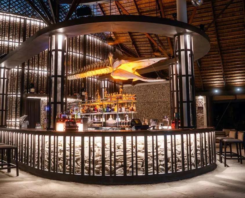 The circular bar at Babuna, backlit shelves of spirits and a whale-skeleton fixture overhead