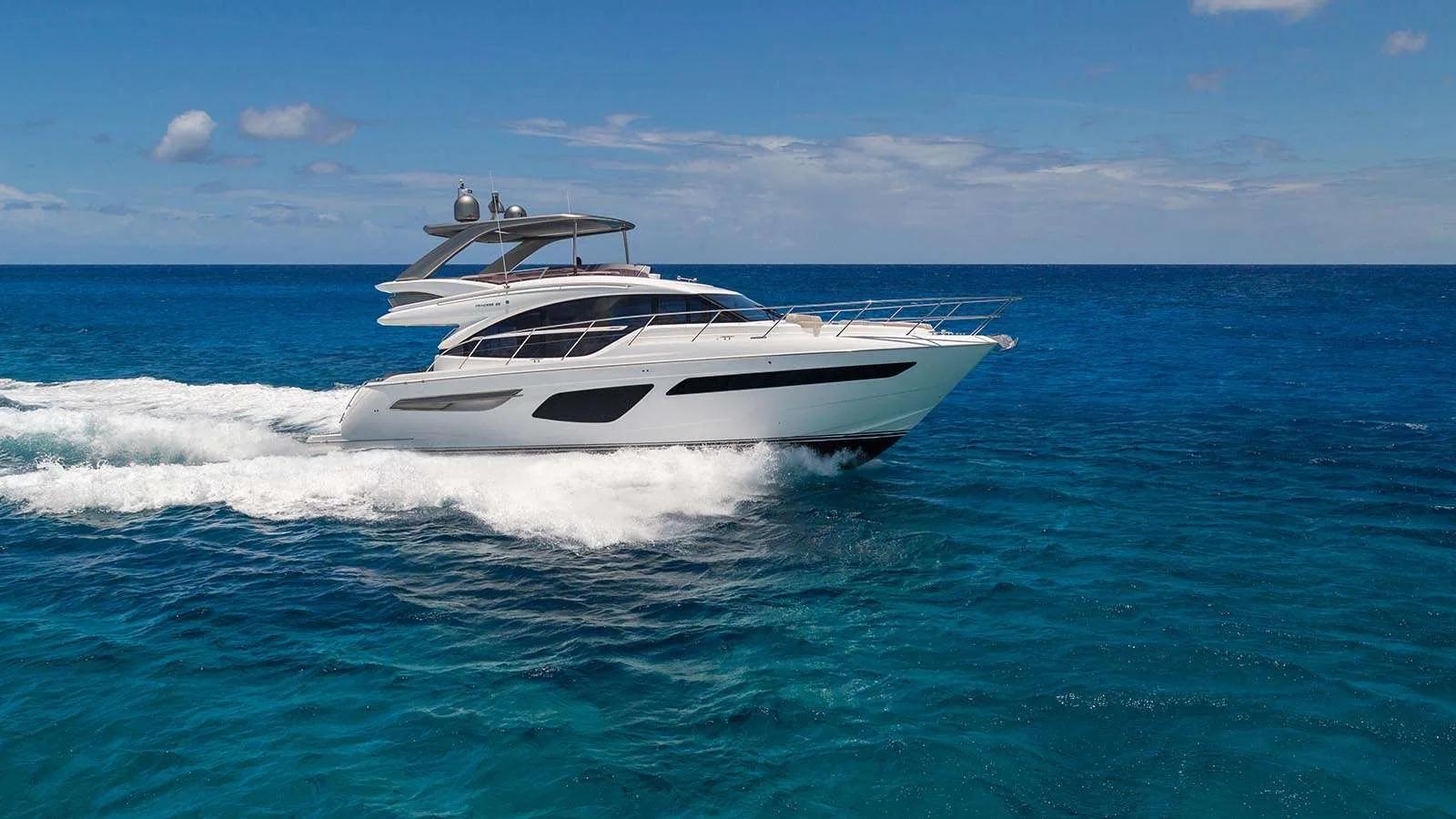 A white motor yacht underway on open water, its wake trailing behind