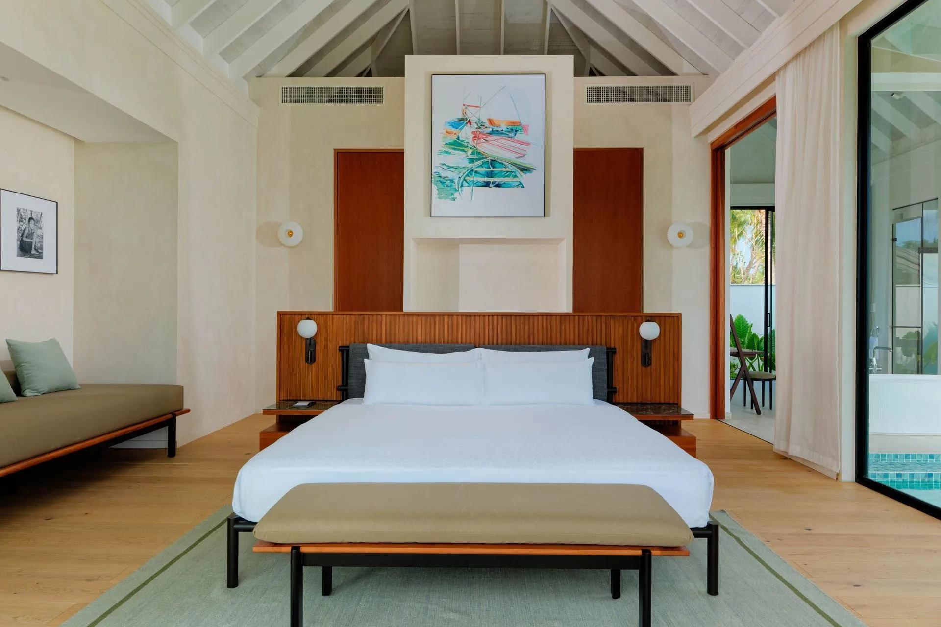 The bedroom of a Deluxe Beach Pool Villa, opening onto its private pool deck