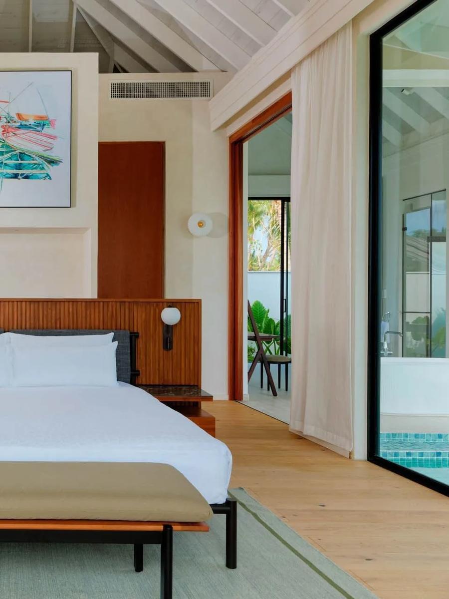 The bedroom of a Deluxe Beach Pool Villa, opening onto its private pool deck