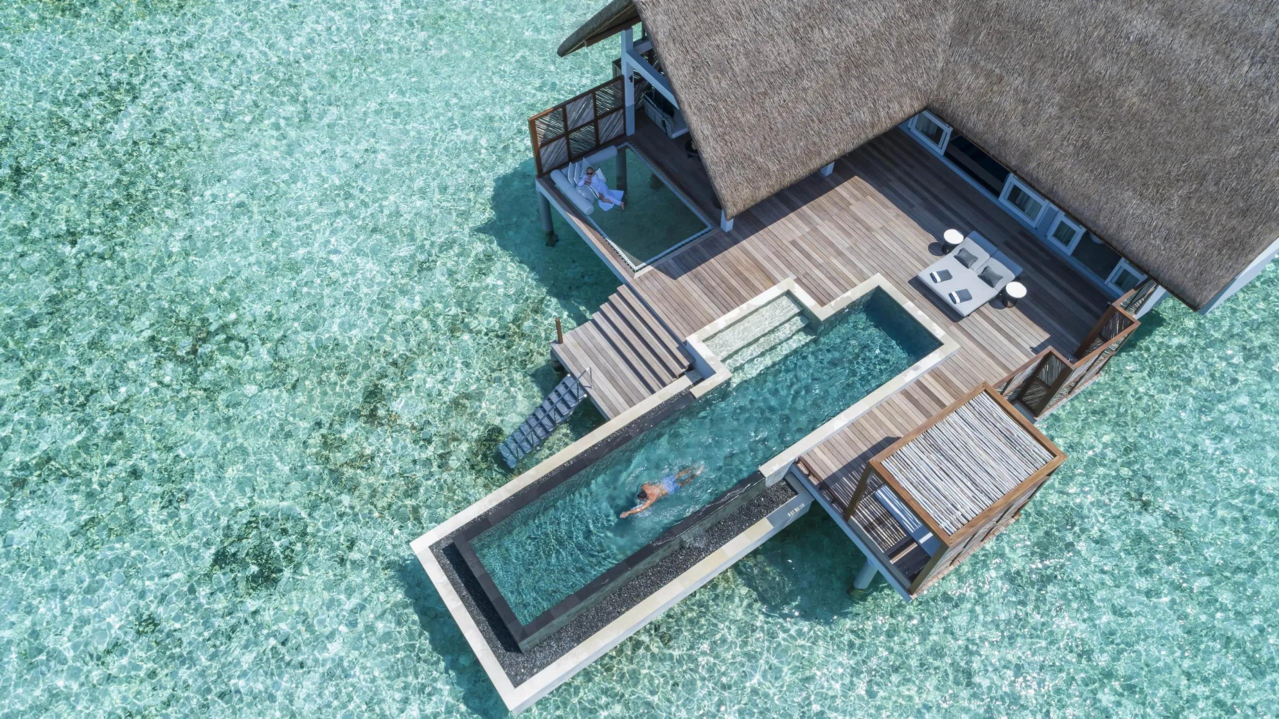 Aerial view of a Sunrise Water Villa with Pool, its thatched roof, deck and plunge pool set over the lagoon