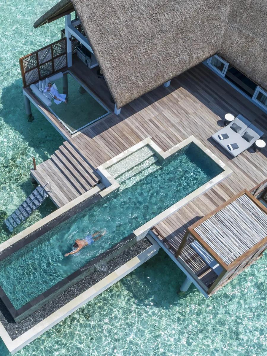 Aerial view of a Sunrise Water Villa with Pool, showing its thatched roof, deck and plunge pool over clear lagoon water