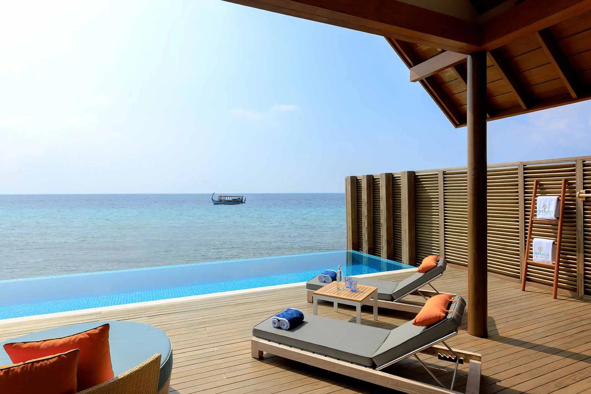 A Superior Water Villa with Pool's living area, opening onto its deck and 4x10 m pool